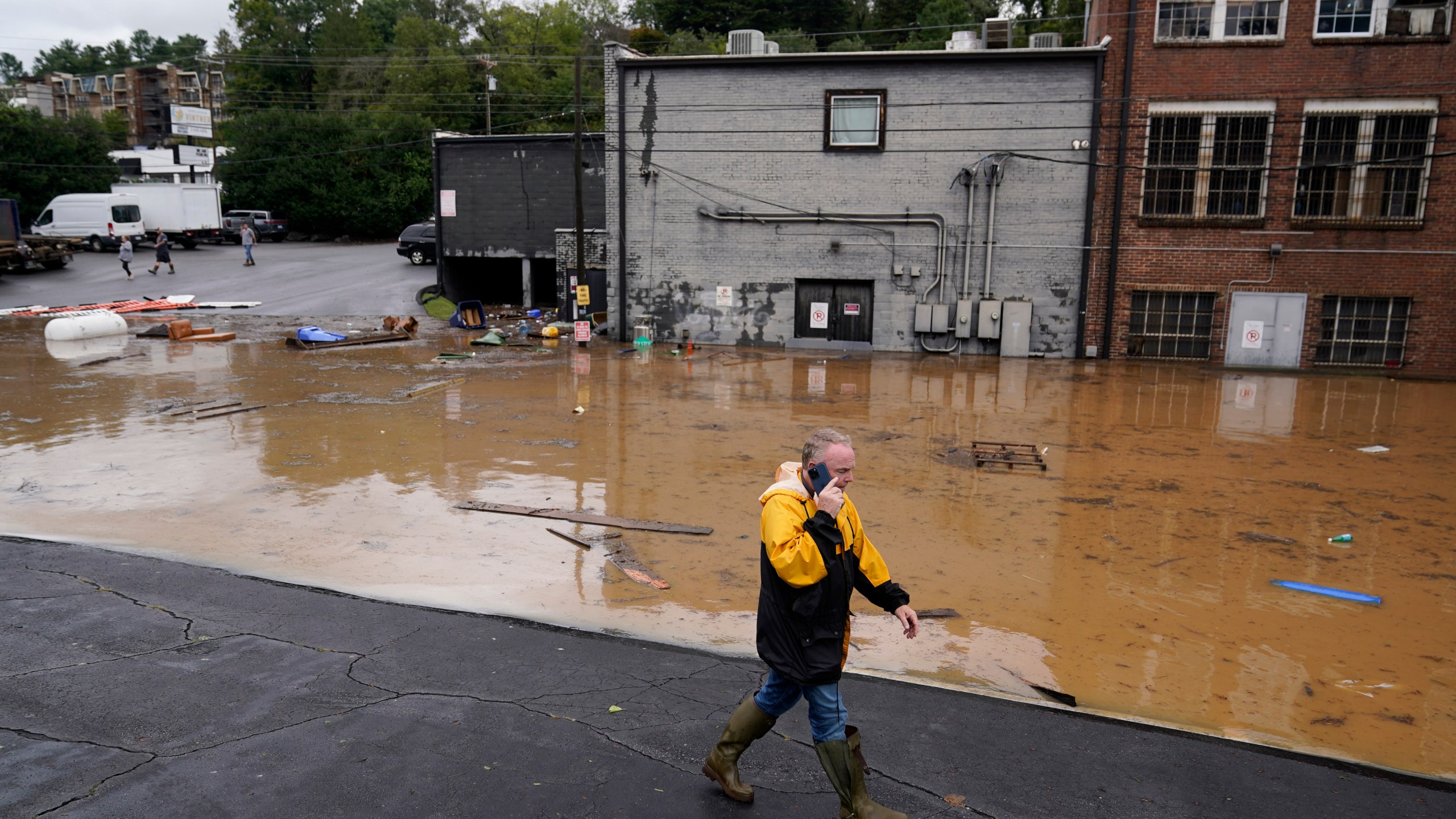 FILE - A man walks near a flooded area near the Swannanoa river, effects from Hurricane Helene , Friday, Sept. 27, 2024, in Asheville, N.C. (AP Photo/Erik Verduzco, File)