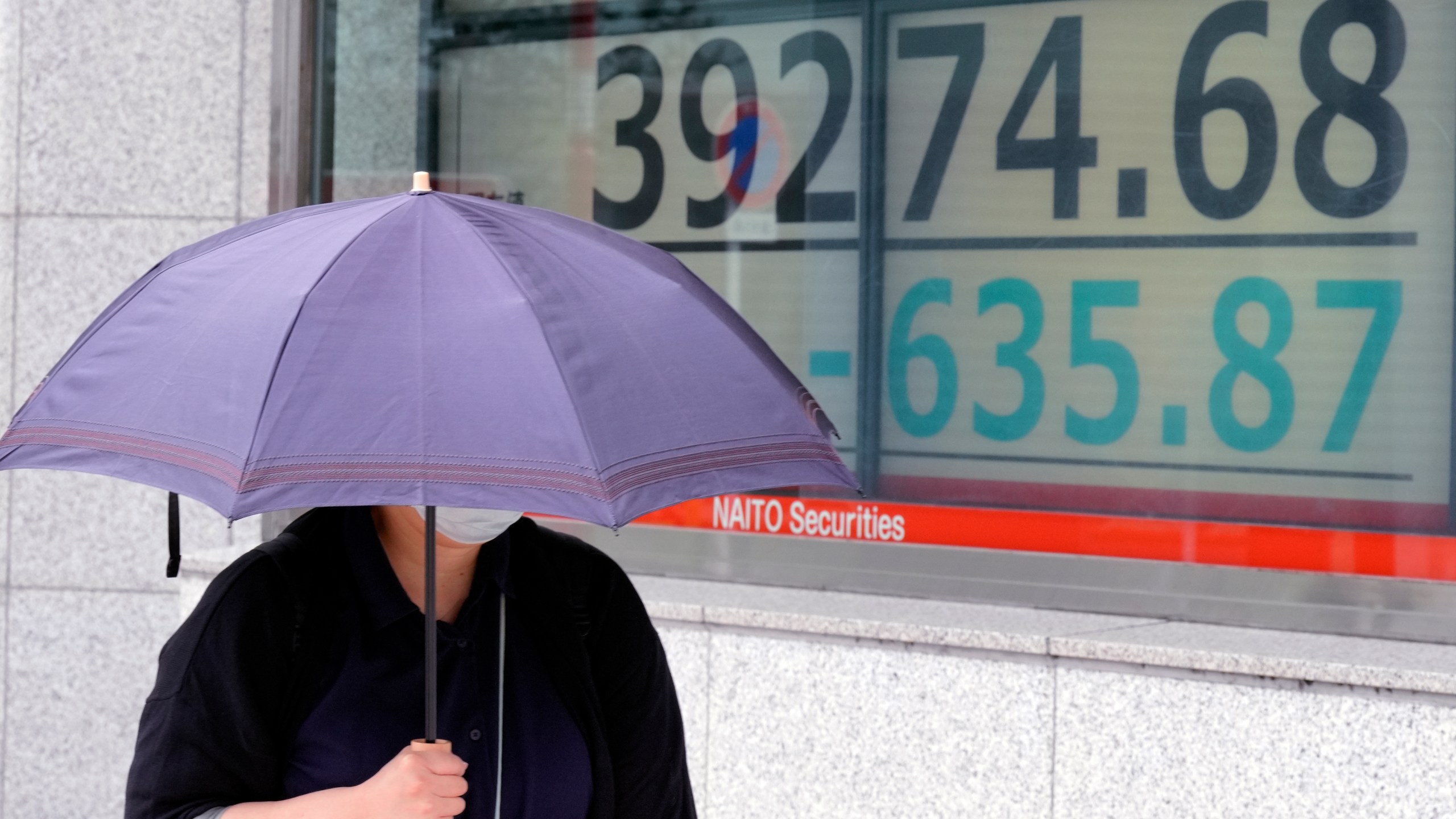 A person walks in front of an electronic stock board showing Japan's Nikkei index at a securities firm Wednesday, Oct. 16, 2024, in Tokyo. (AP Photo/Eugene Hoshiko)