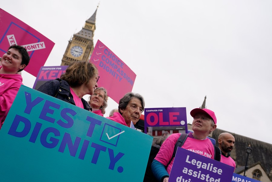 A small demonstration by people advocating assisted dying hold a protest outside the Hoses of Parliament as a bill to legalise assisted dying is to be put before lawmakers in London, England, Wednesday, Oct. 16, 2024. (AP Photo/Alberto Pezzali)