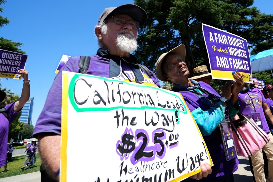 FILE - Retirees Ron Martin, left, and Willie Mae Hampton, right, join other supporters of the Service Employees International Union at a rally against proposed budget cuts to state provided social safety net programs, in Sacramento, Calif., Tuesday, June 11, 2024. (AP Photo/Rich Pedroncelli, File)