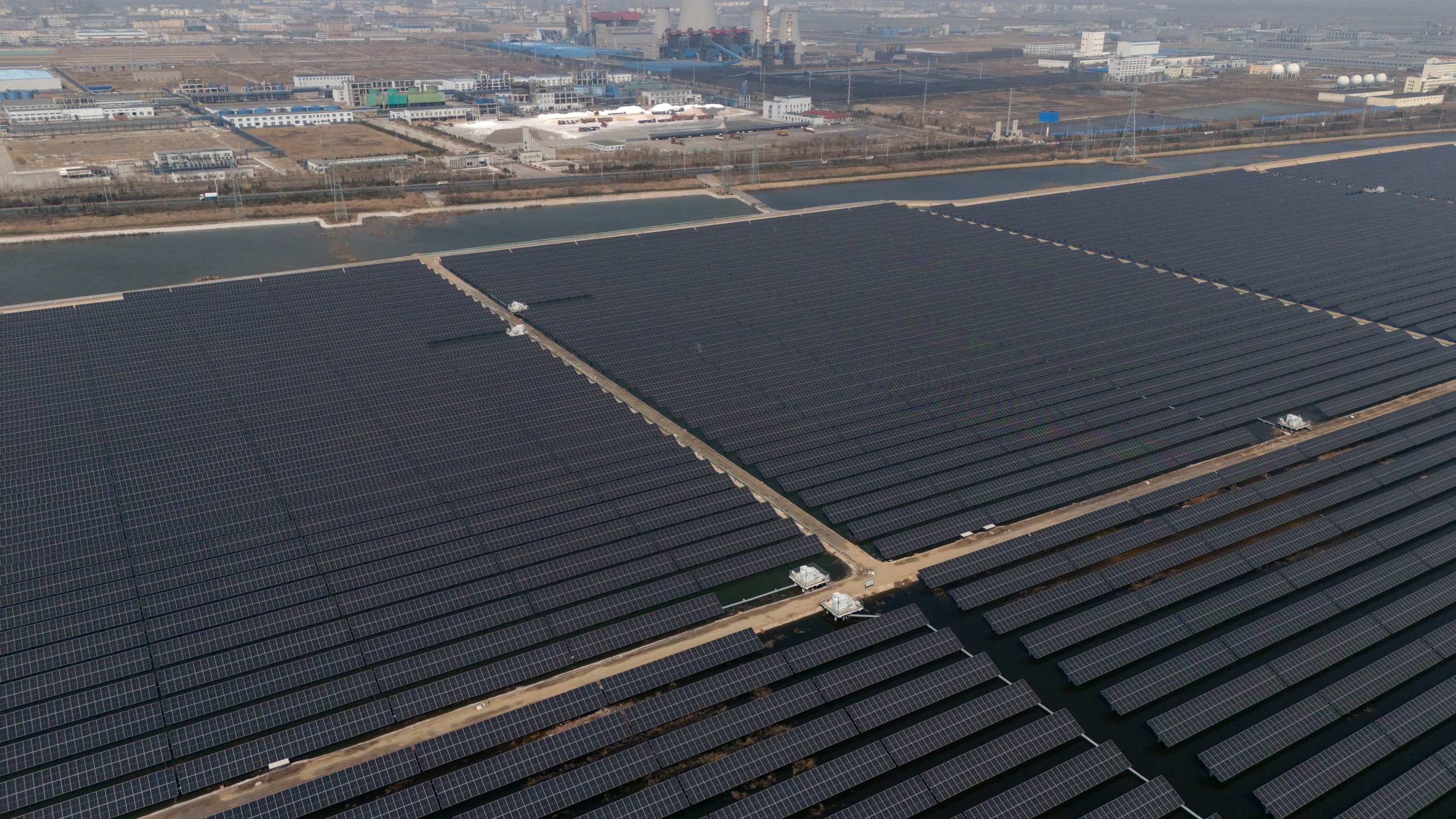 FILE - A solar farm operates near a chemical plant on the outskirts of Weifang in eastern China's Shandong province on March 22, 2024. (AP Photo/Ng Han Guan, File)