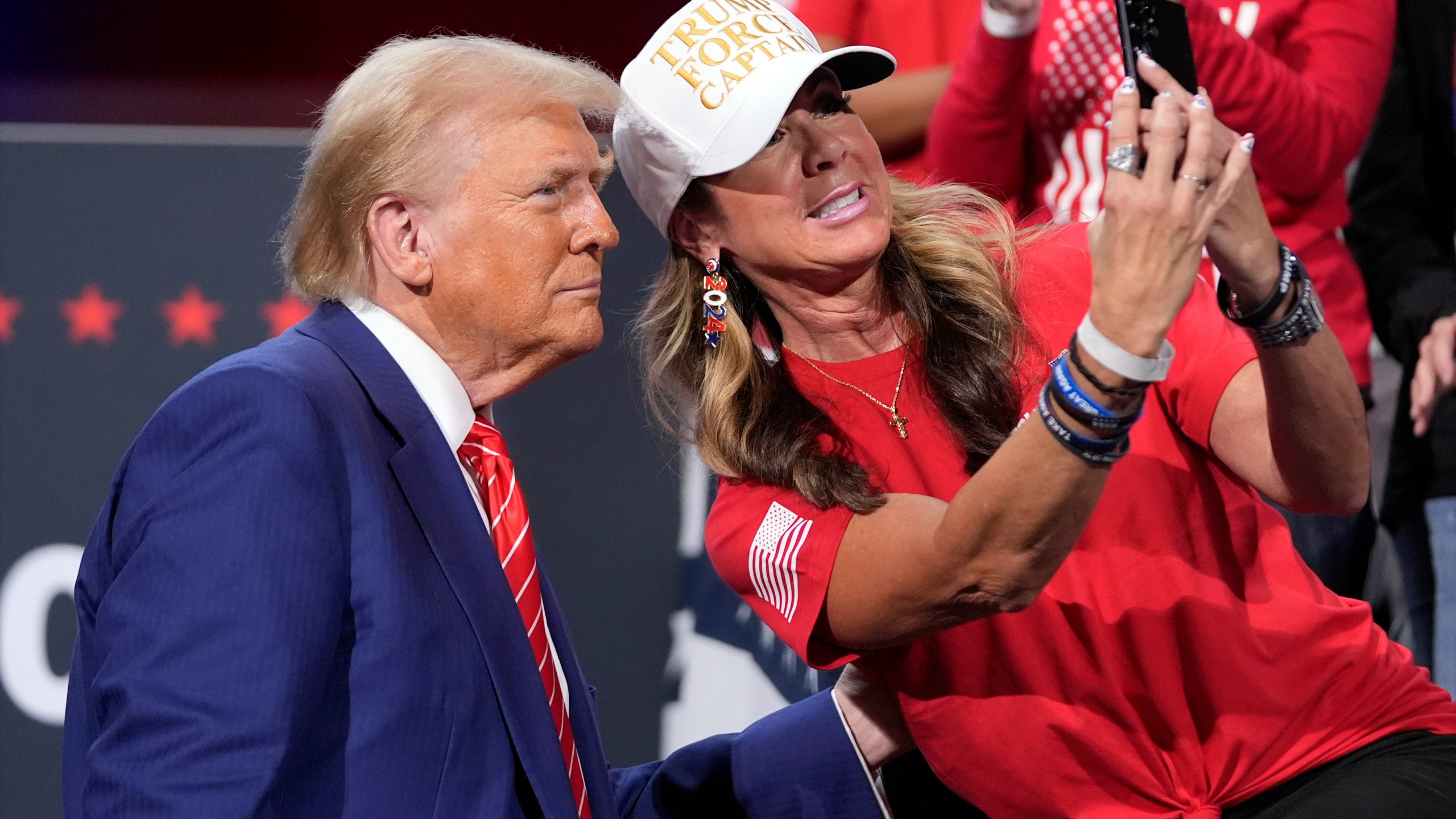 Republican presidential nominee former President Donald Trump poses for a photo with a supporter at a campaign event at the Cobb Energy Performing Arts Centre, Tuesday, Oct. 15, 2024, in Atlanta. (AP Photo/Alex Brandon)