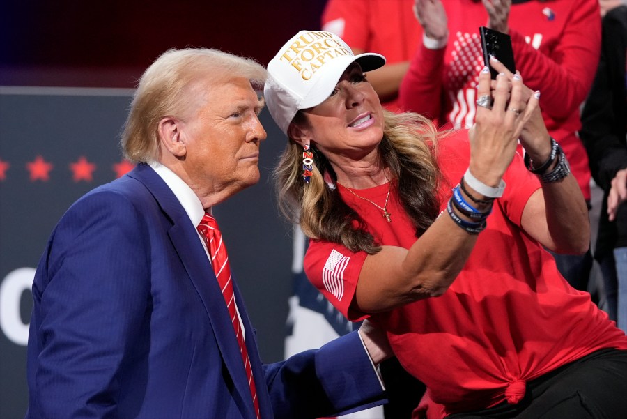 Republican presidential nominee former President Donald Trump poses for a photo with a supporter at a campaign event at the Cobb Energy Performing Arts Centre, Tuesday, Oct. 15, 2024, in Atlanta. (AP Photo/Alex Brandon)