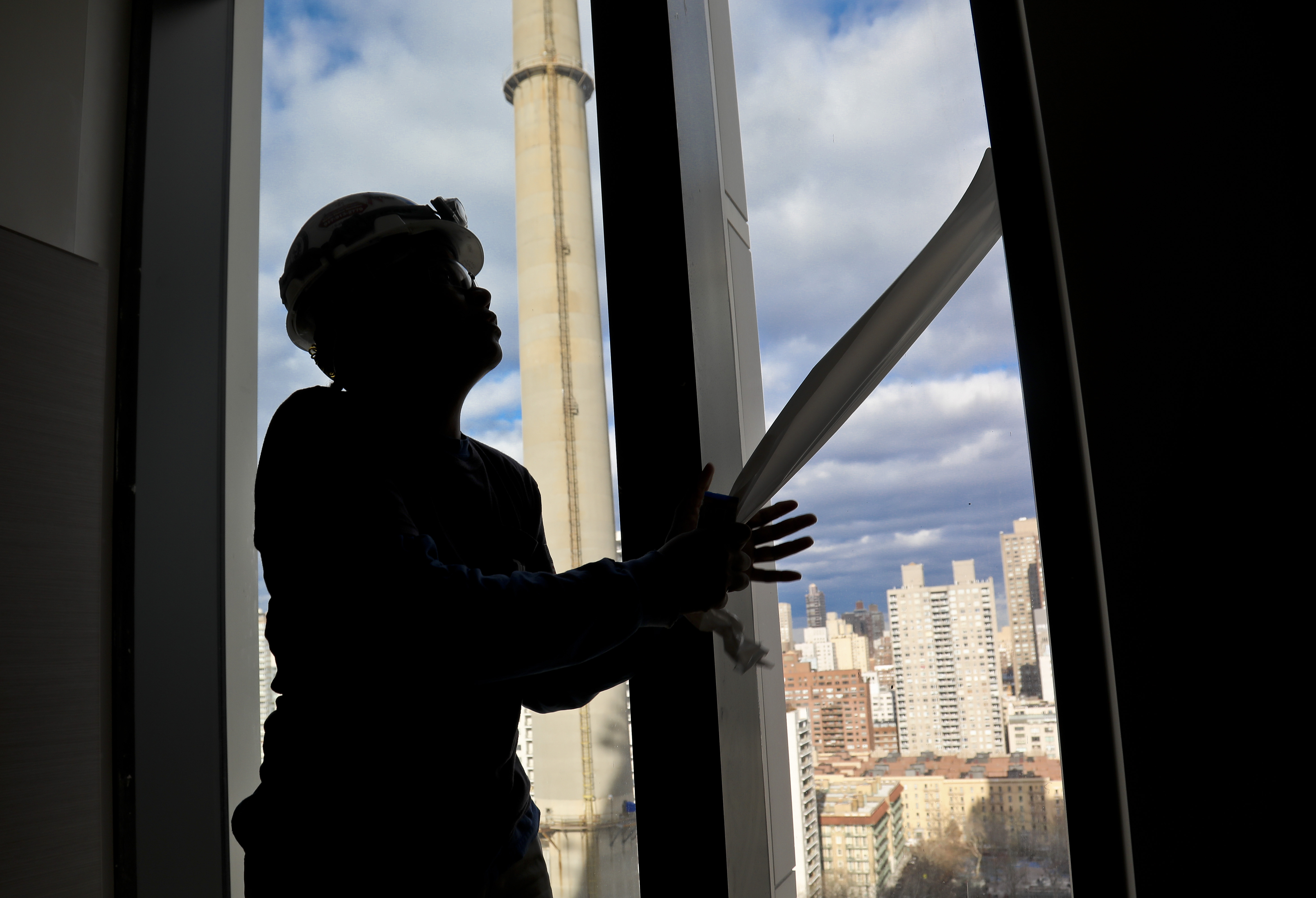 FILE - Construction laborer Myrtle Wilson prepares for a the installation of windows on a building on Jan. 9, 2019 in New York. (AP Photo/Bebeto Matthews, File)