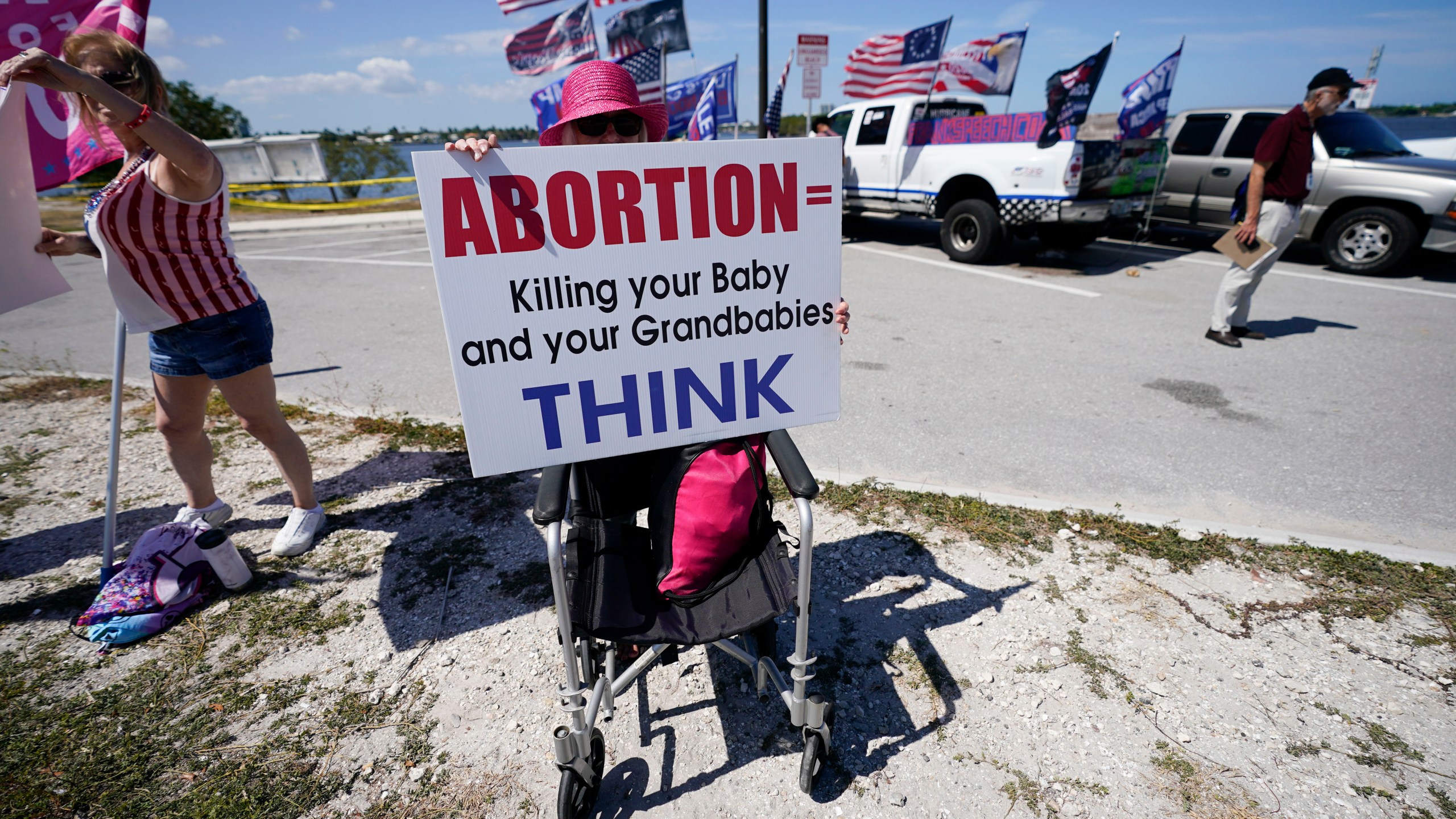 FILE - Leona Mangan of Lakeworth, Fla., holds a sign as she gathers with other supporters of former President Donald Trump outside his Mar-a-Lago estate in West Palm Beach, Fla., March 21, 2023. (AP Photo/Gerald Herbert, file)