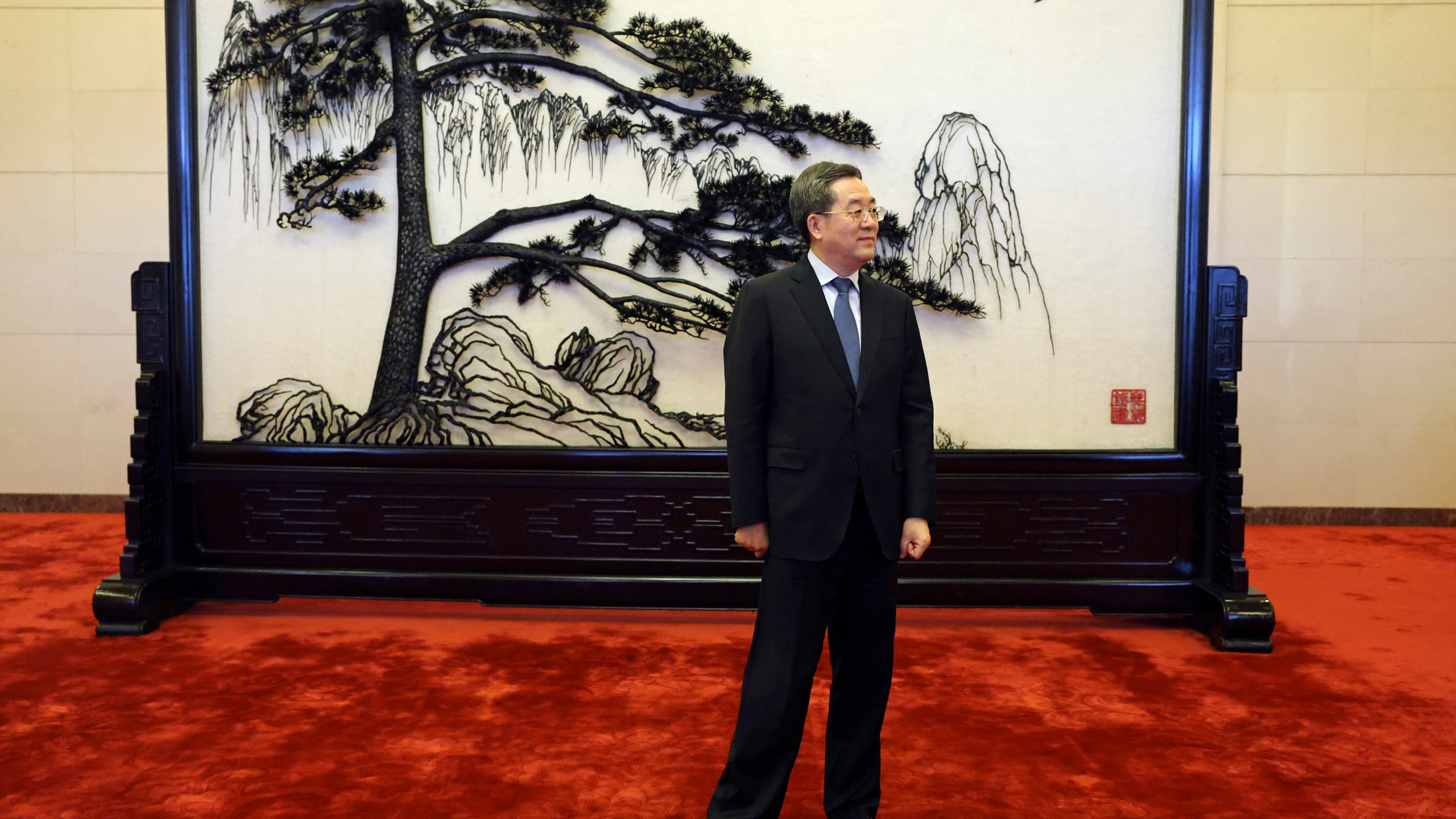 Chinese Vice Premier Ding Xuexiang waits for a handshake with Britain's Foreign Secretary David Lammy at the Great Hall of the People in Beijing Friday, Oct. 18, 2024. (Florence Lo/Pool Photo via AP)