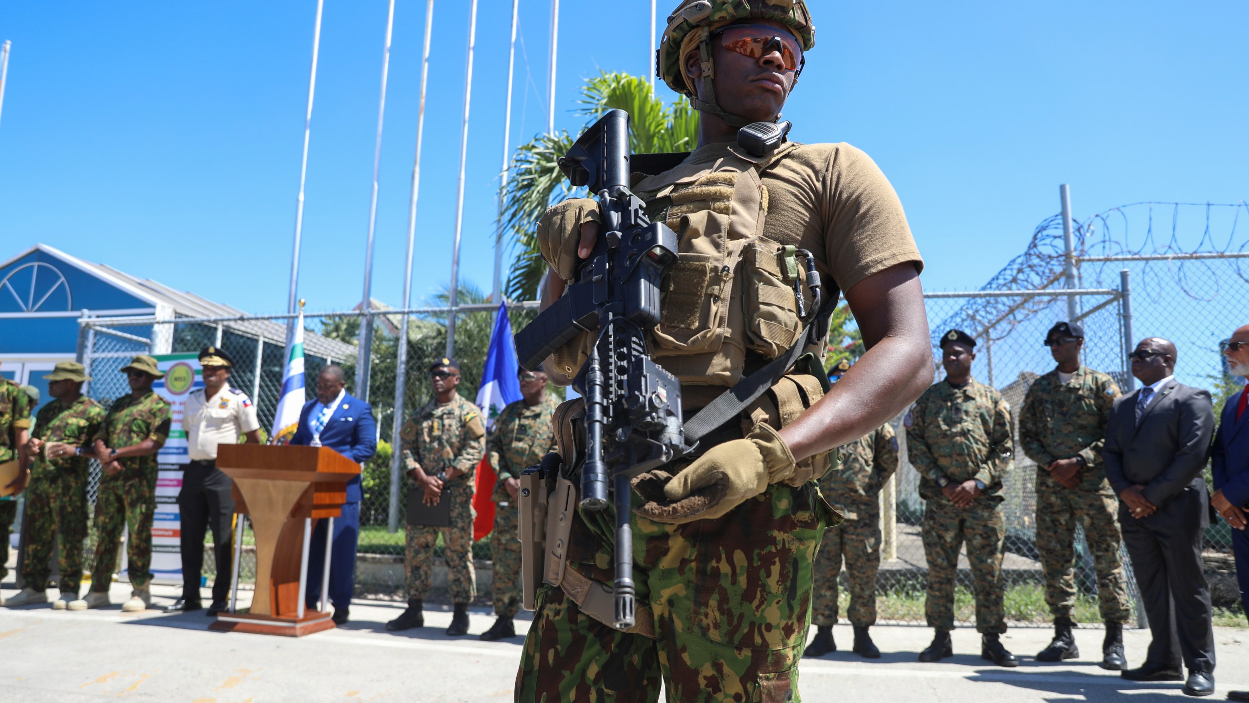 A Kenyan police officer, part of a UN-backed multinational force, stands guard on the tarmac during a ceremony to welcome police officers from the Bahamas at the Toussaint Louverture International Airport in Port-au-Prince, Haiti, Friday, Oct. 18, 2024. (AP Photo/Odelyn Joseph)