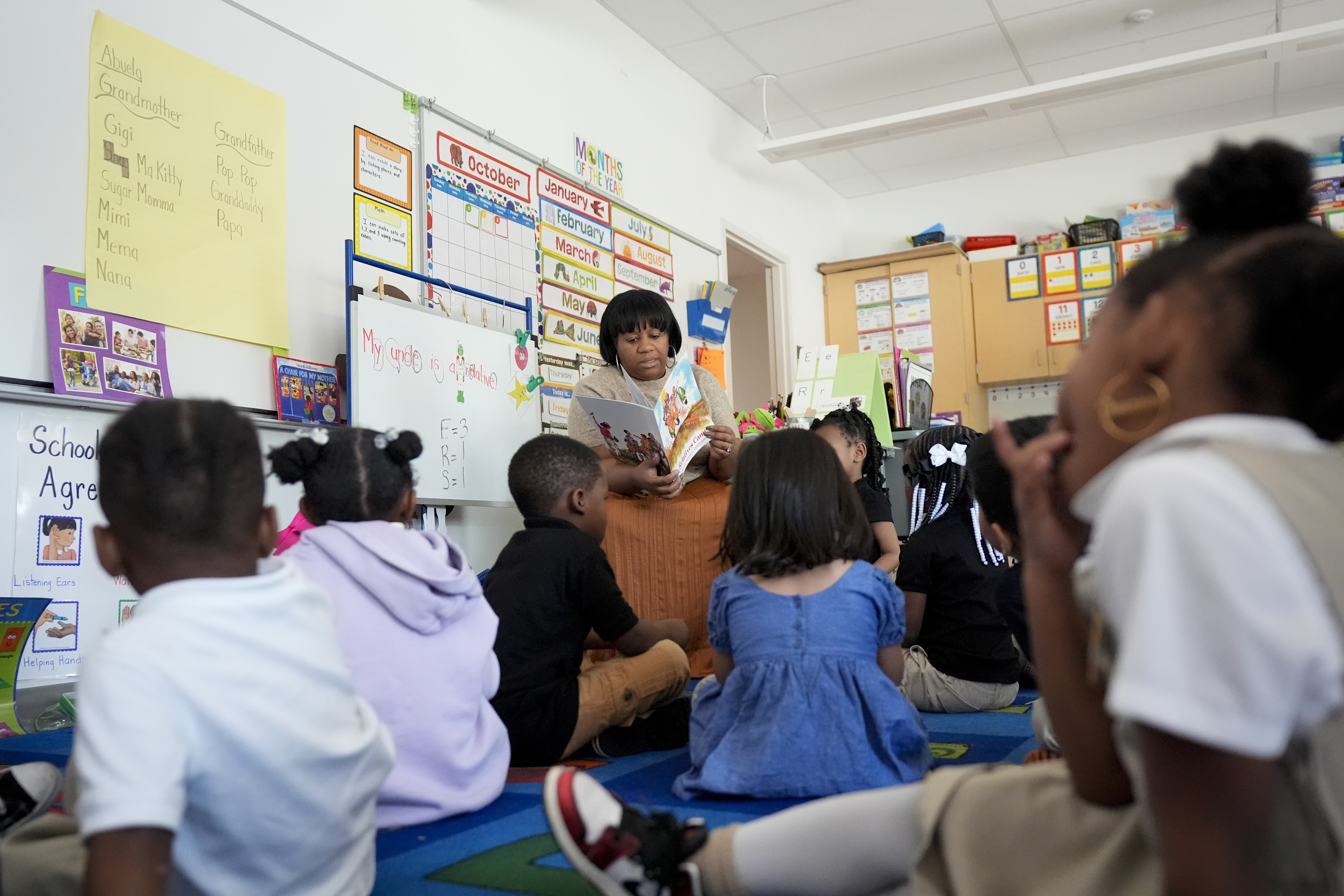 Preschool teacher Bridget Jeffreys reads to students, Thursday, Oct. 3, 2024, at Dorothy I. Height Elementary School in Baltimore. (AP Photo/Stephanie Scarbrough)