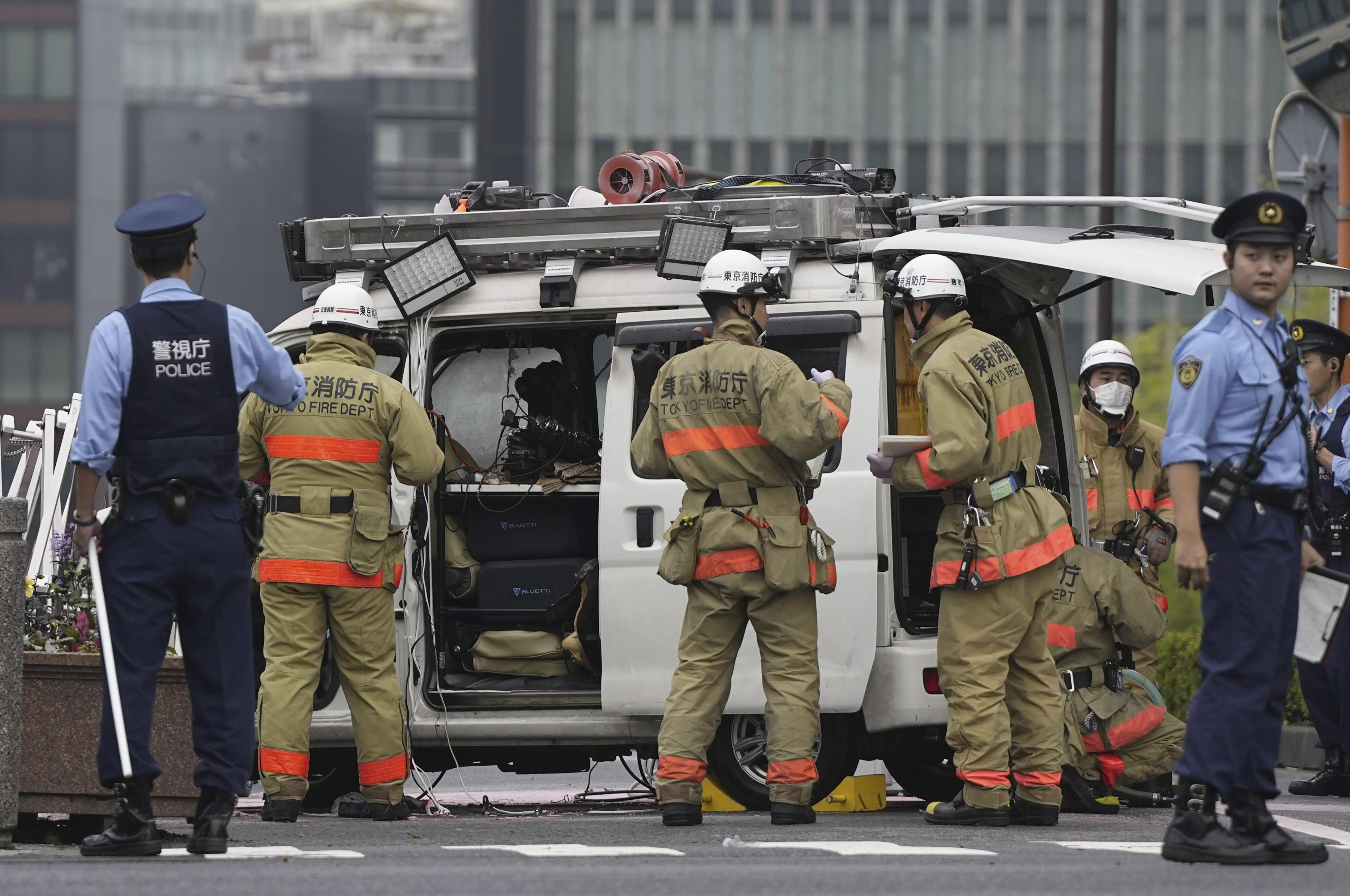 Officials work near a vehicle which was stuck against a security fence near the prime minister's office in Tokyo Saturday, Oct. 19, 2024. (Kyodo News via AP)