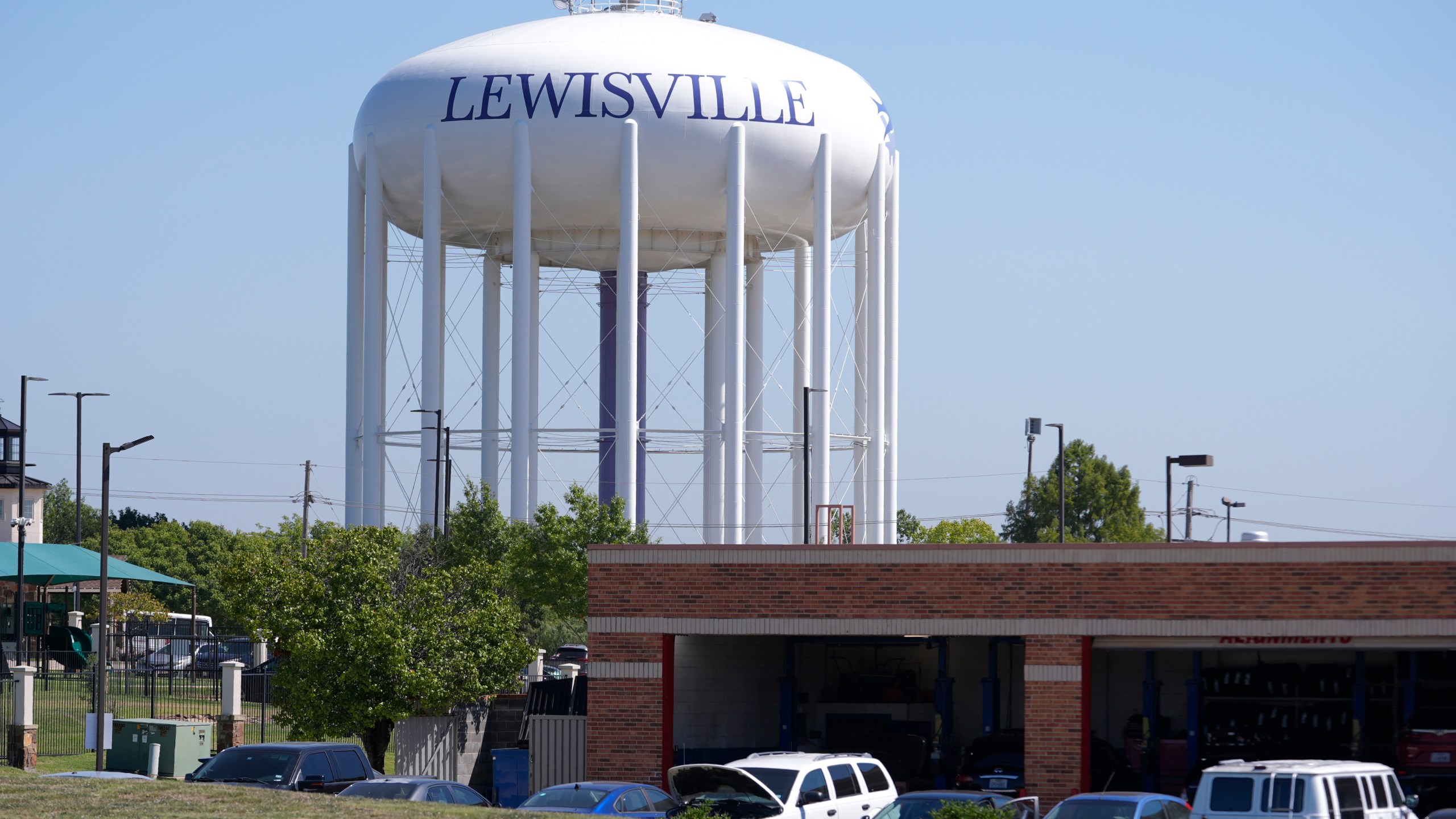 A water tower sits near businesses in Lewisville, Texas, Wednesday, Oct. 2, 2024. (AP Photo/LM Otero)