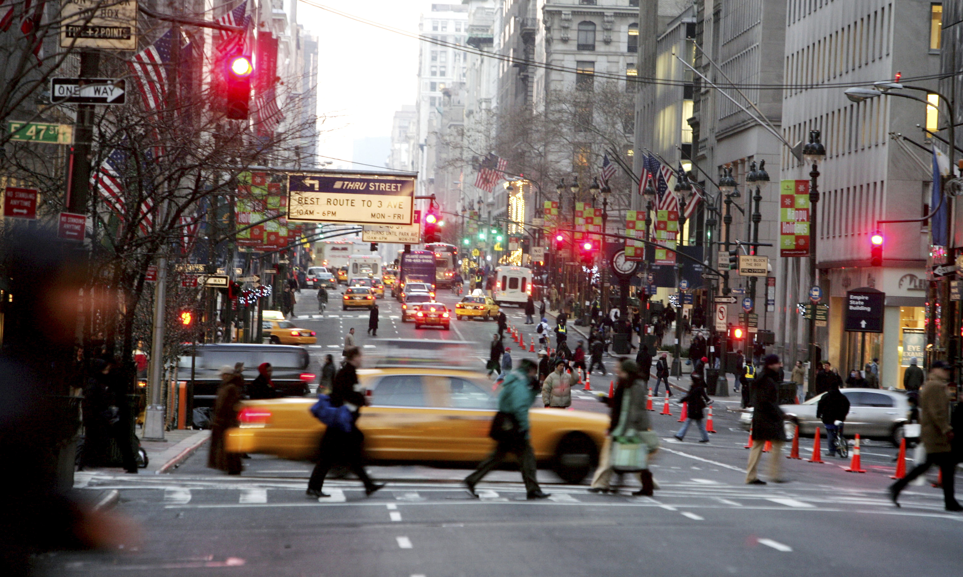 FILE - Vehicles and pedestrians make their way down Fifth Avenue in New York, Dec. 22, 2005, . (AP Photo/Diane Bondareff, File)