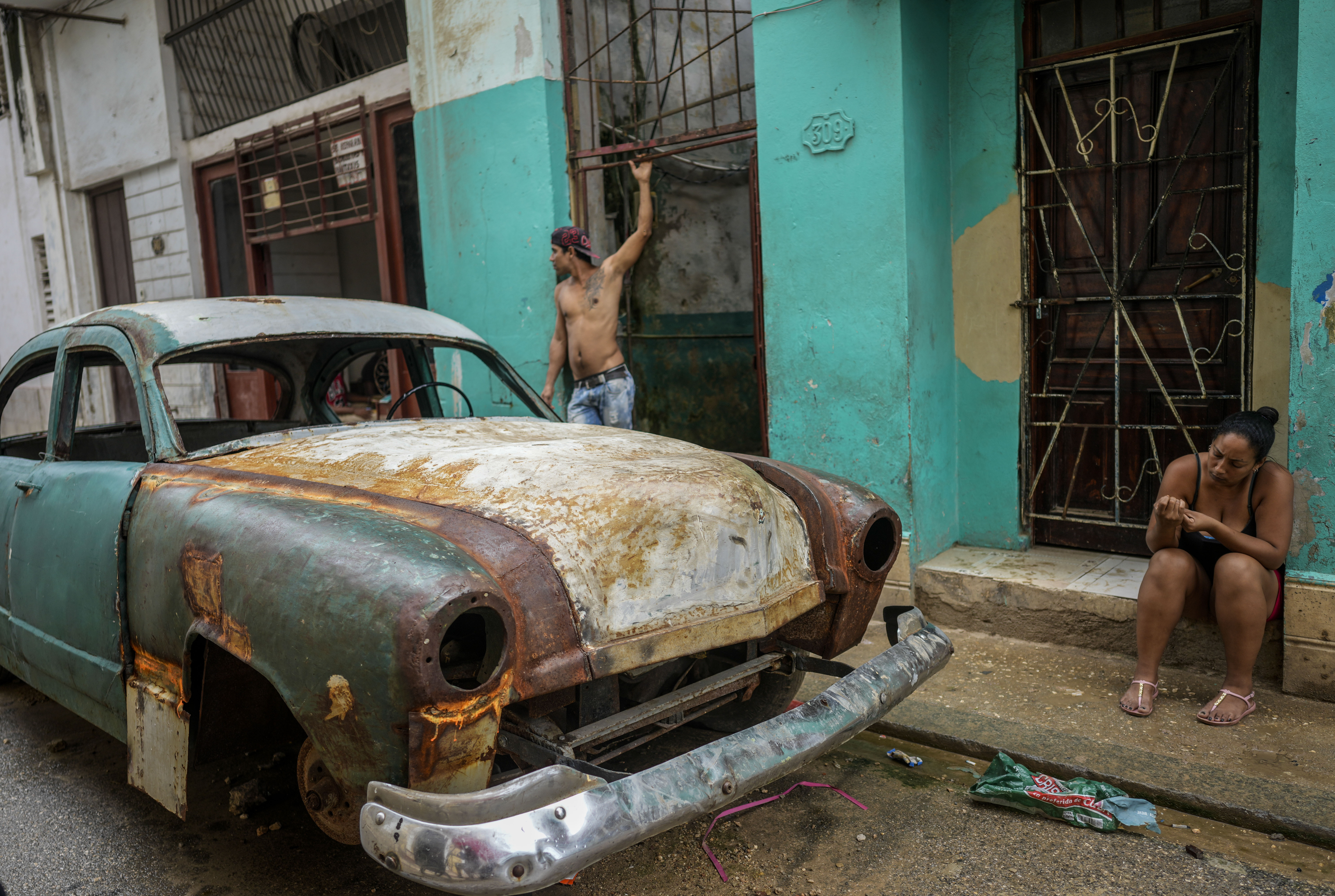 Residents stand outside their homes to avoid the heat indoors during a massive blackout after a major power plant failed in Havana, Cuba, Saturday, Oct. 19, 2024. (AP Photo/Ramon Espinosa)