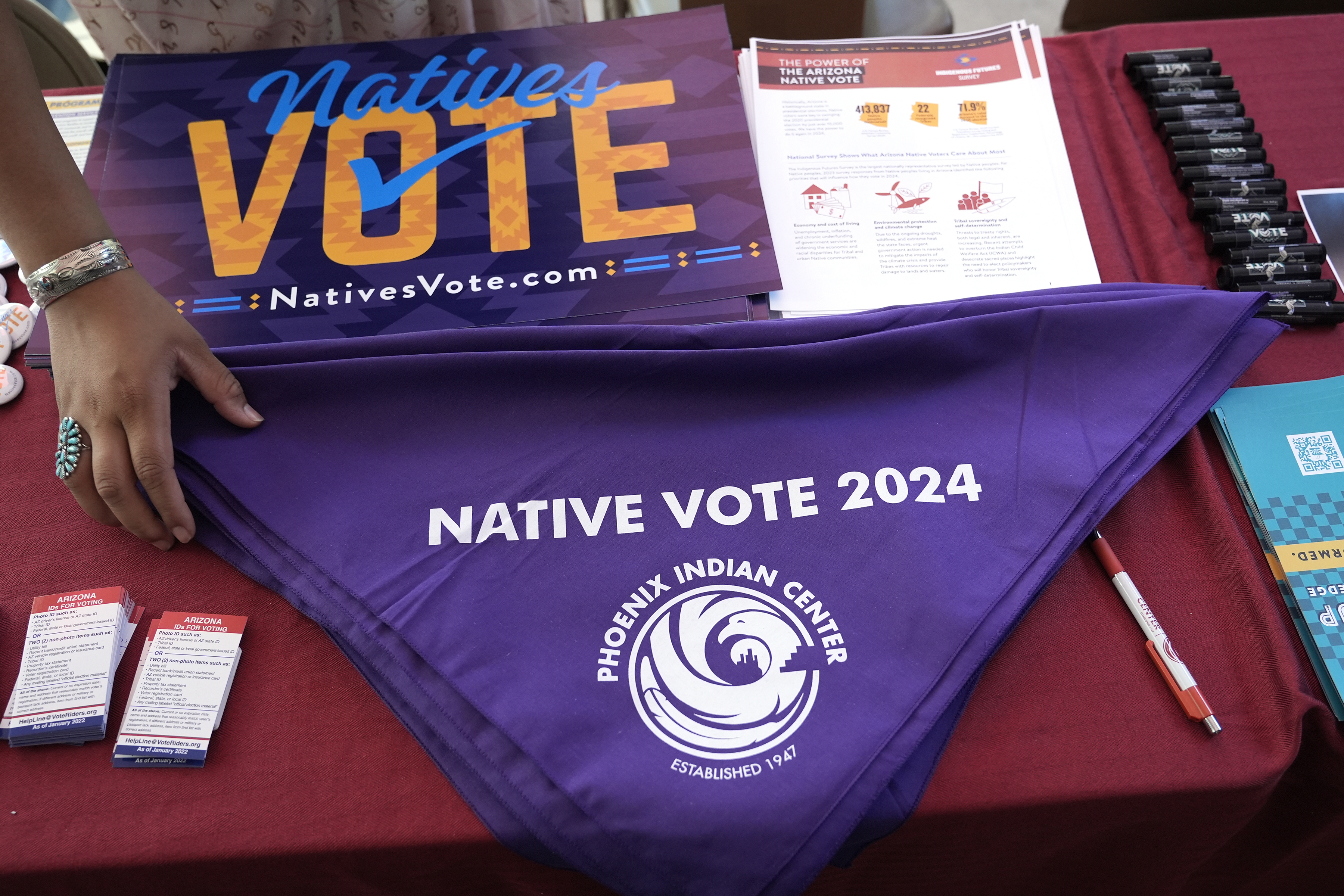 Voter information is on display at a Phoenix Indian Center booth during an Indigenous Peoples' Day event, Monday, Oct. 14, 2024, in Phoenix. (AP Photo/Ross D. Franklin)