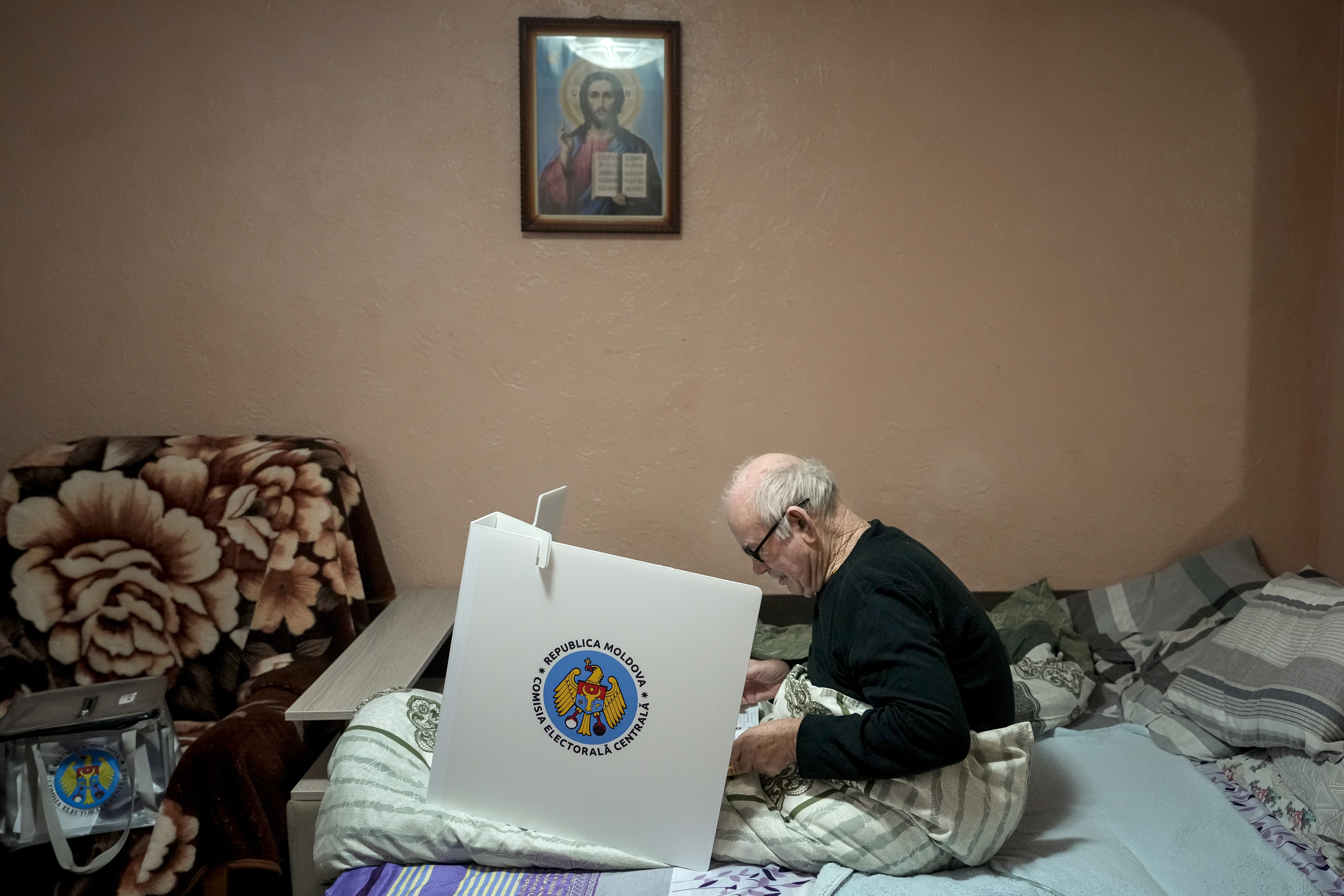 A man casts his vote in a mobile ballot box in the village of Hrusevo, Moldova, Sunday, Oct. 20, 2024, during a presidential election and a referendum on whether to enshrine in the Constitution the country's path to European Union membership. (AP Photo/Vadim Ghirda)