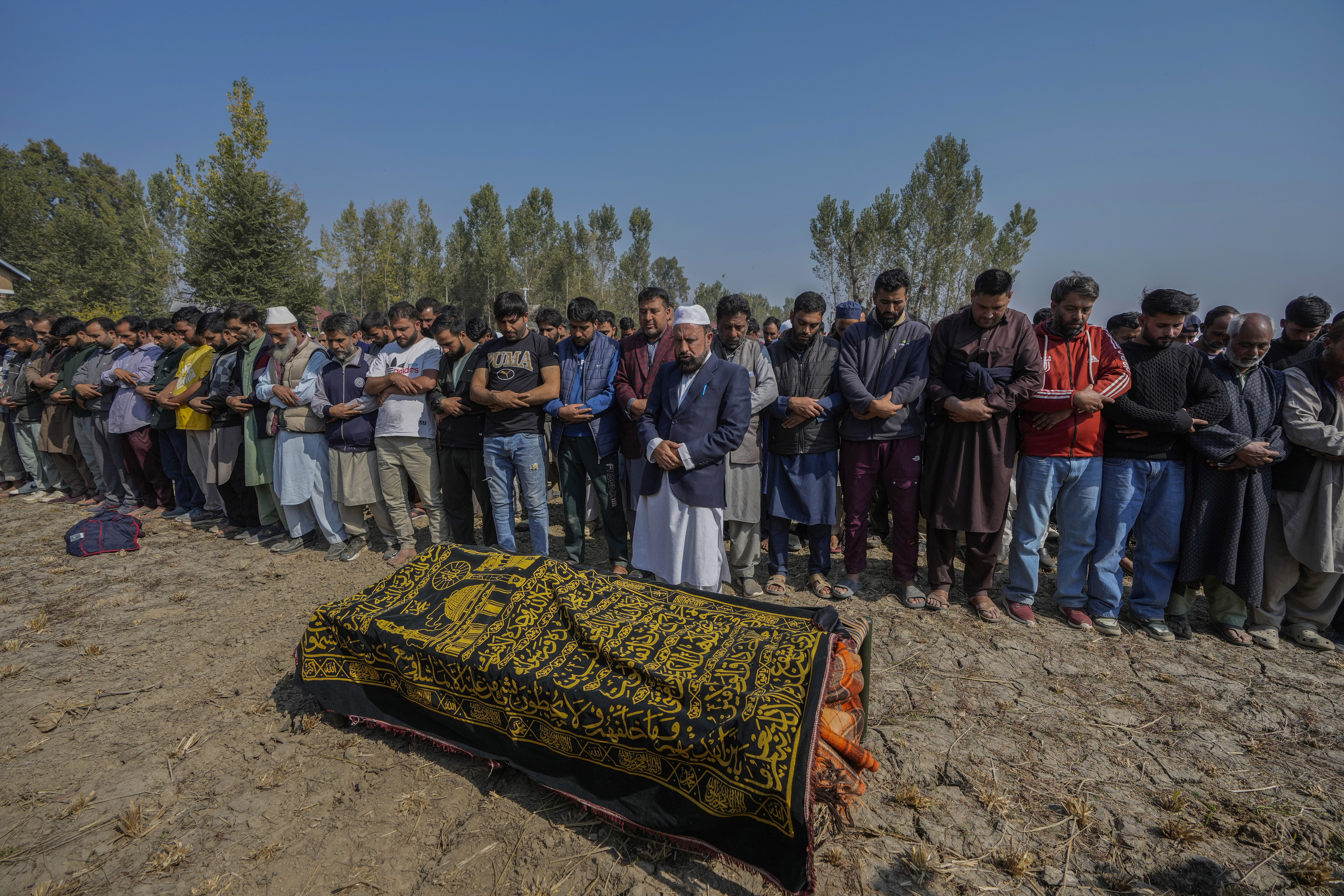 Villagers offer funeral prayers near the body of Kashmiri doctor Shahnawaz who was among those killed when gunmen fired at people working on a strategic tunnel project in Indian-controlled Kashmir, at Nadigam village southwest of Srinagar, Monday, Oct. 21, 2024. (AP Photo/Mukhtar Khan)