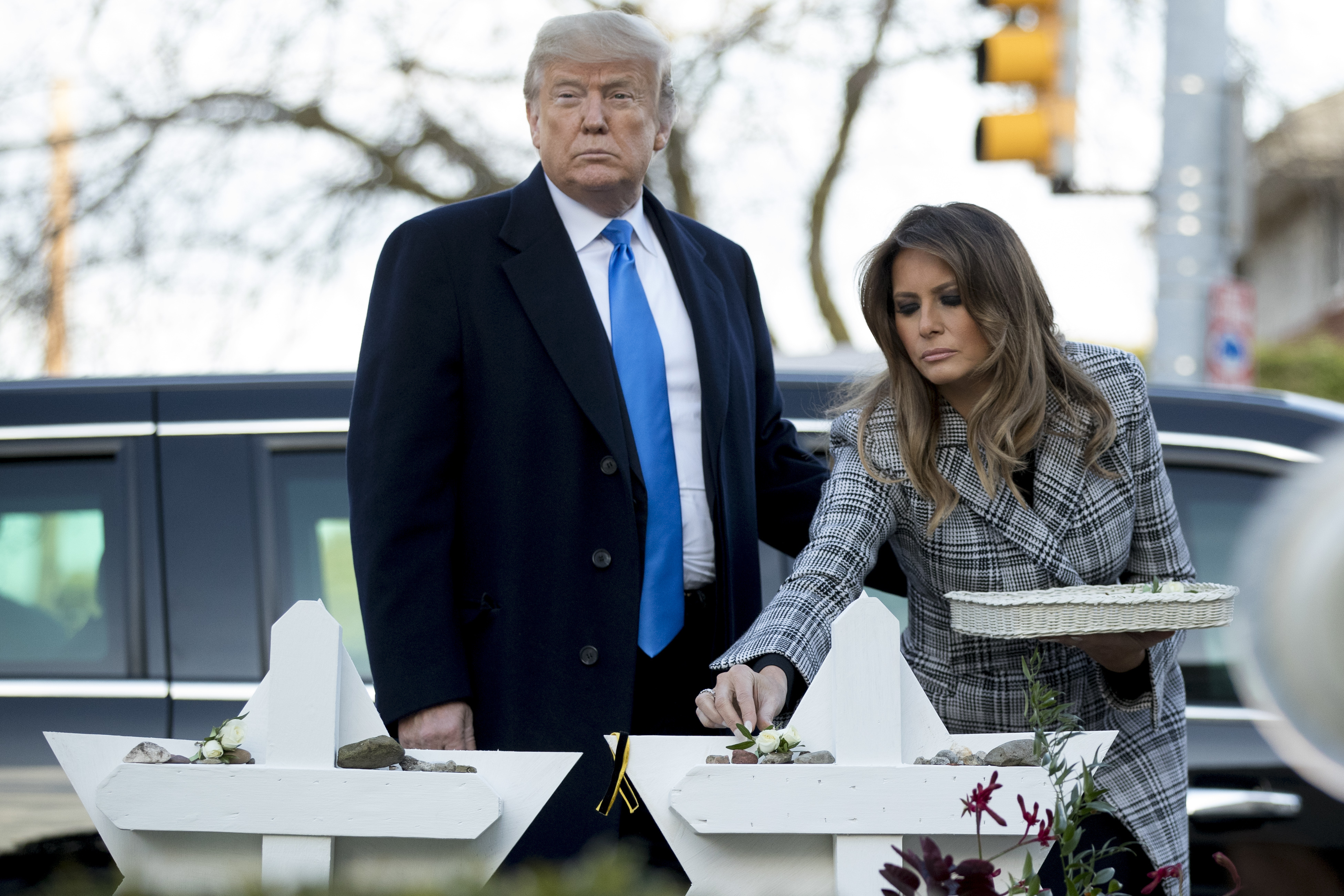 FILE - First lady Melania Trump, accompanied by President Donald Trump, puts down a white flower at a memorial for those killed at the Tree of Life Synagogue in Pittsburgh, Oct. 30, 2018. (AP Photo/Andrew Harnik, File)