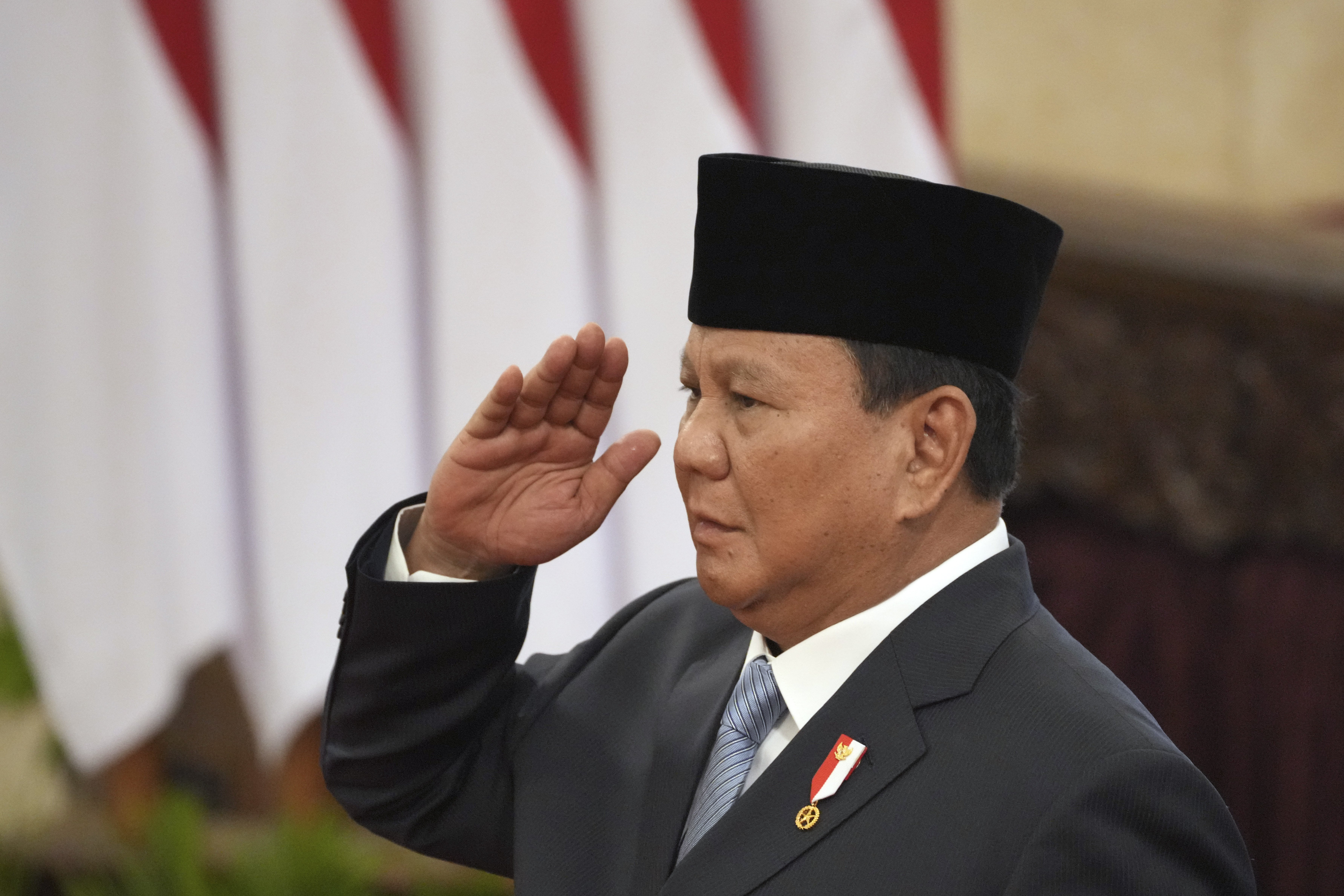 Indonesian President Prabowo Subianto salutes during the swearing-in ceremony of the new cabinet ministers at the presidential palace in Jakarta, Indonesia, Monday, Oct. 21, 2024. (AP Photo/Achmad Ibrahim)