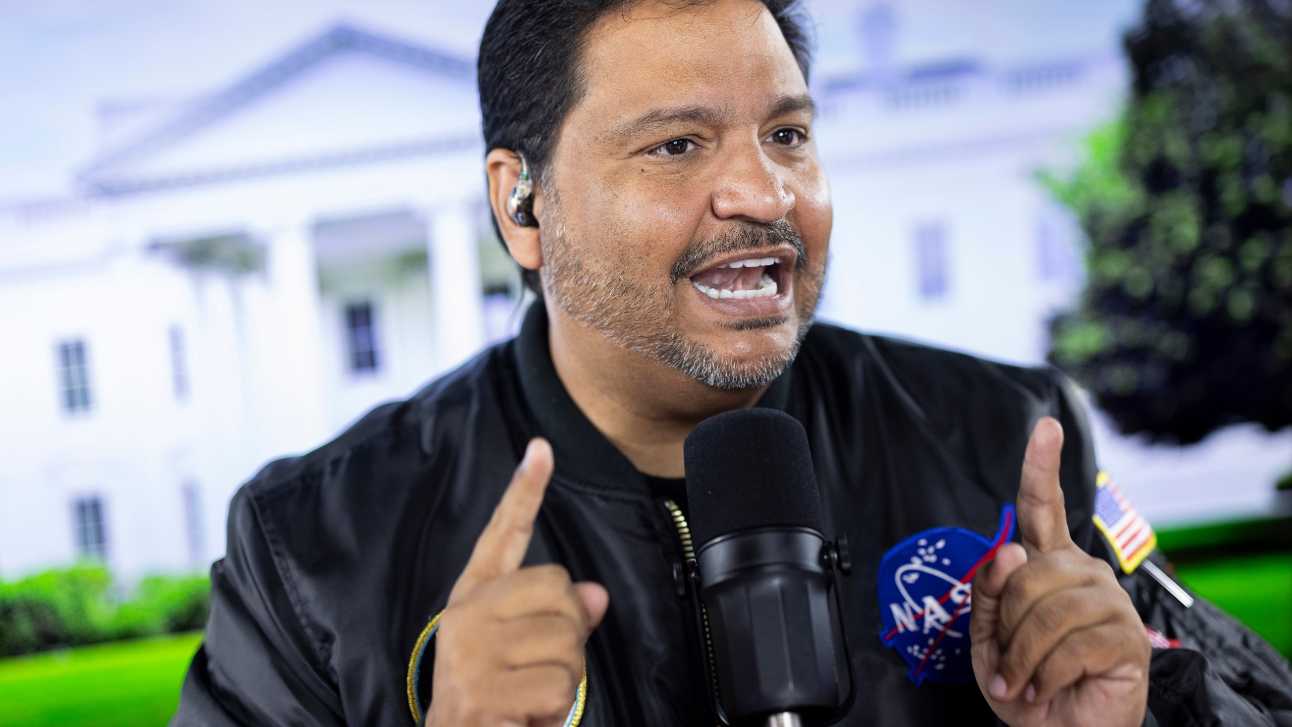 Radio host and owner of radio station La Mega 101.7 FM Victor Martinez on the air in Allentown, Pa, Tuesday, Oct. 15, 2024. (AP Photo/Ryan Collerd)