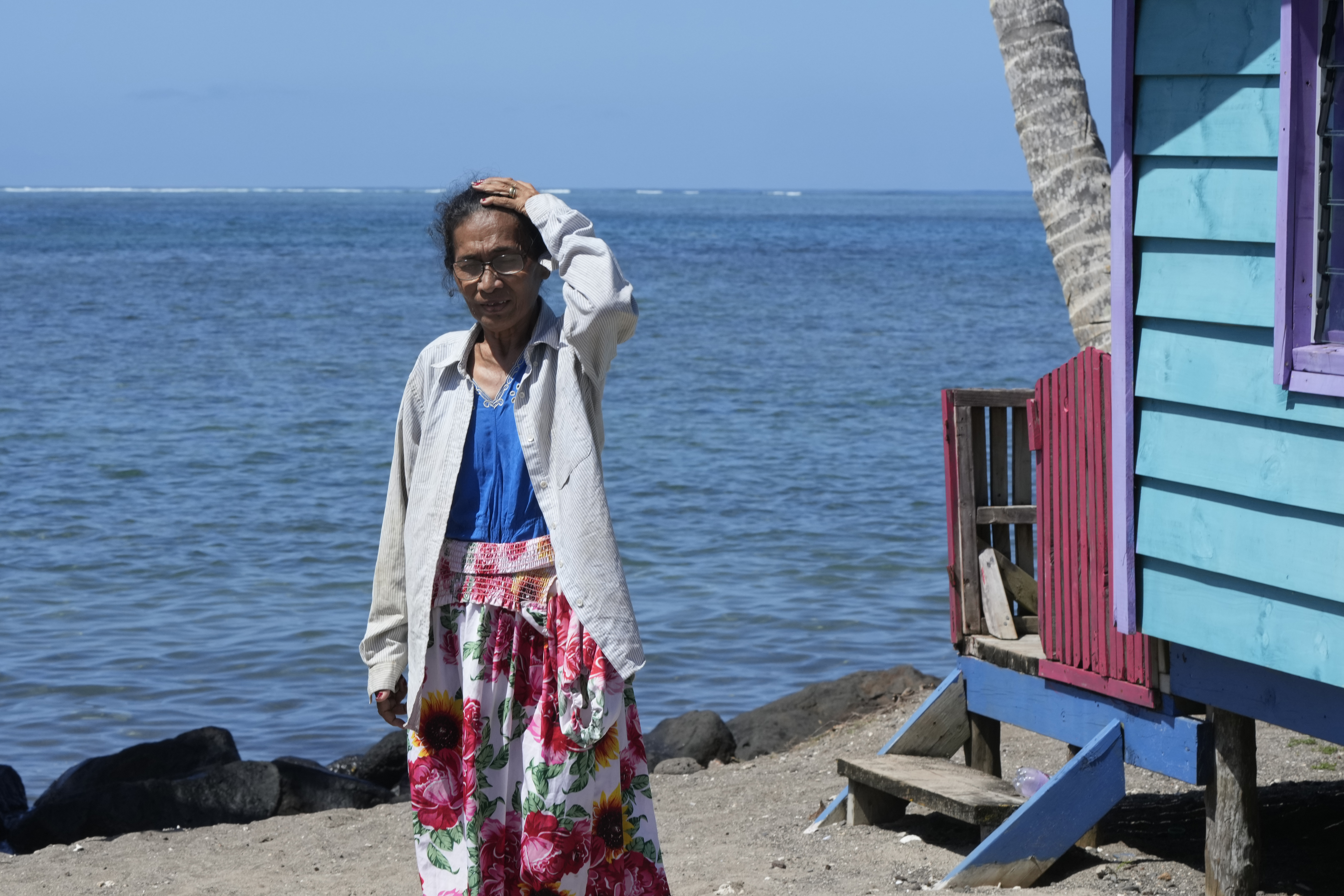 Netina Malae walks past a hut at her Sima PJ Beach Fale resort in the village of Tafitoala, Samoa, on Monday, Oct. 21, 2024, near where a New Zealand navy ship ran aground and sank on Oct. 6. (AP Photo/Rick Rycroft)