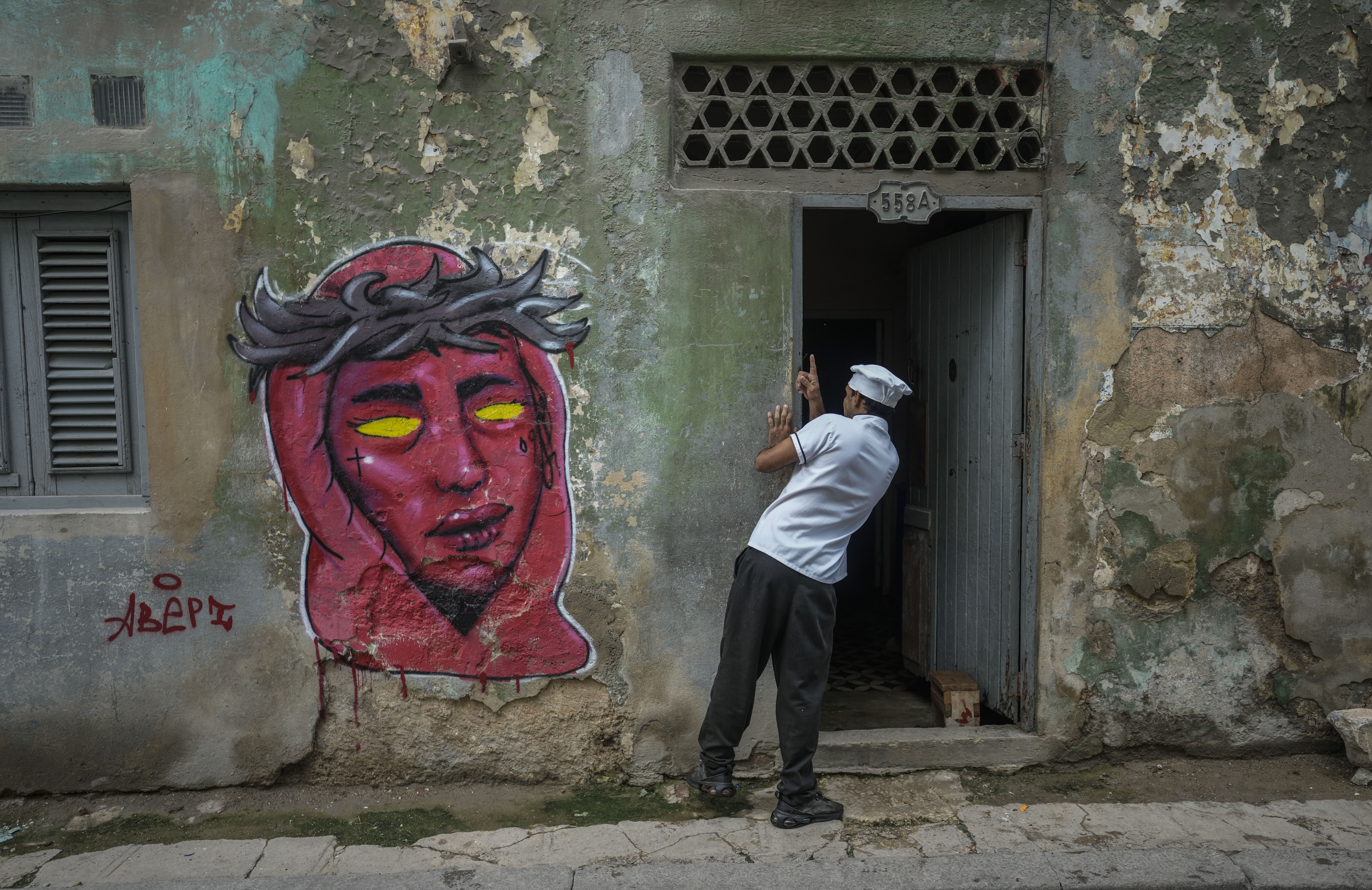 A cook looks in on a resident during a massive blackout after a major power plant failed in Havana, Cuba, Saturday, Oct. 19, 2024. (AP Photo/Ramon Espinosa)