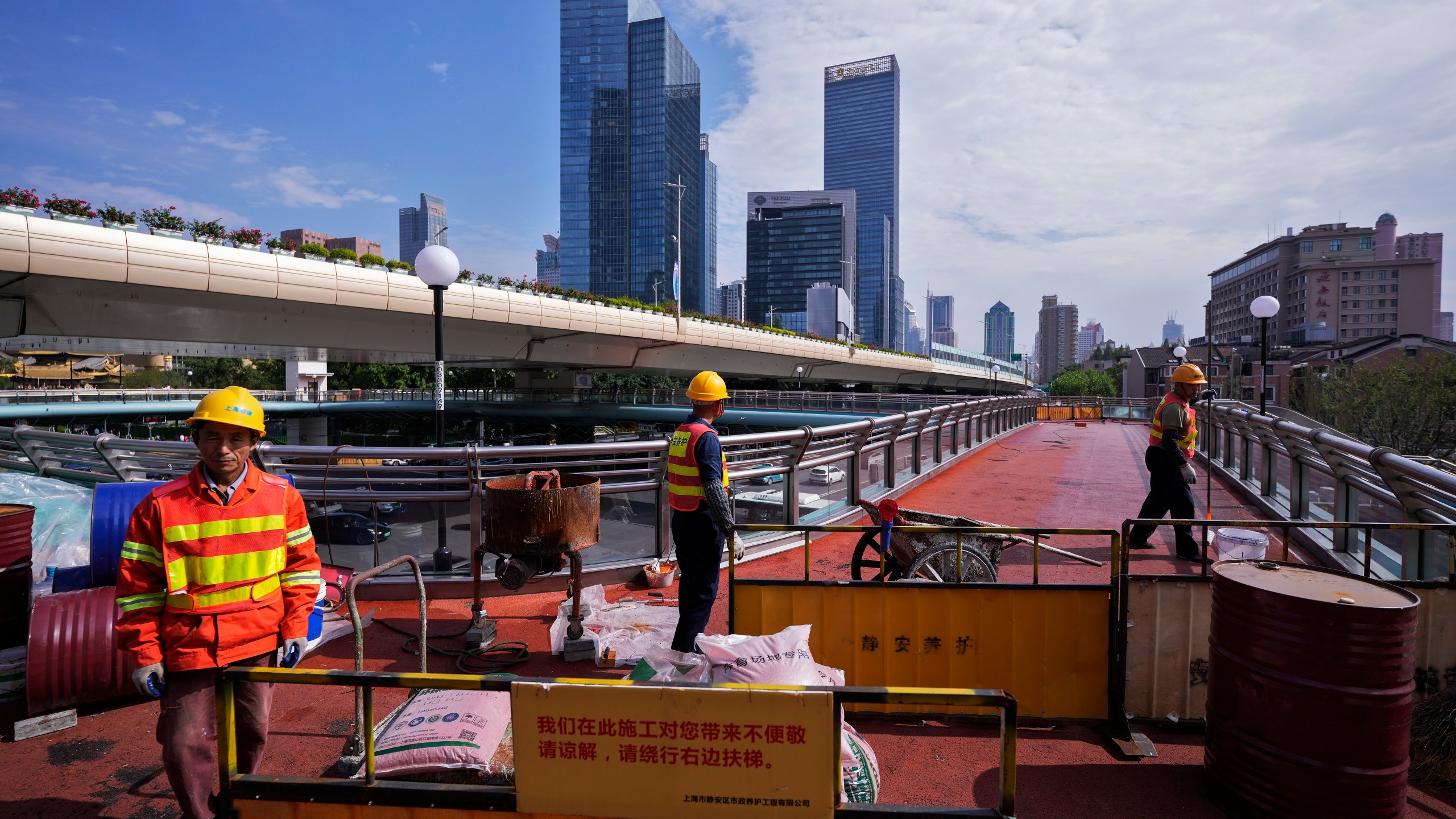 FILE - Workers refurbish an overhead pedestrian bridge in Shanghai on Oct. 9, 2024. (AP Photo/Andy Wong, File)