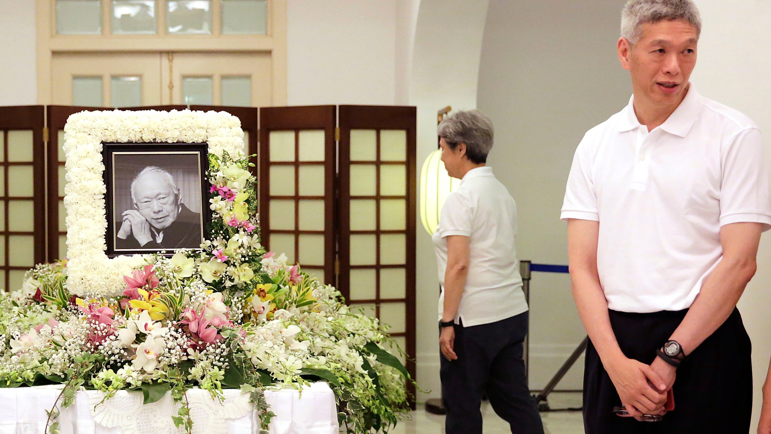 FILE - Prime Minister Lee Hsien Loong's brother, Lee Hsien Yang, right, receives friends and family members paying their respects to the late Lee Kuan Yew during a private family wake at the Istana or Presidential Palace in Singapore, March 24, 2015. (AP Photo/Wong Maye-E, File)