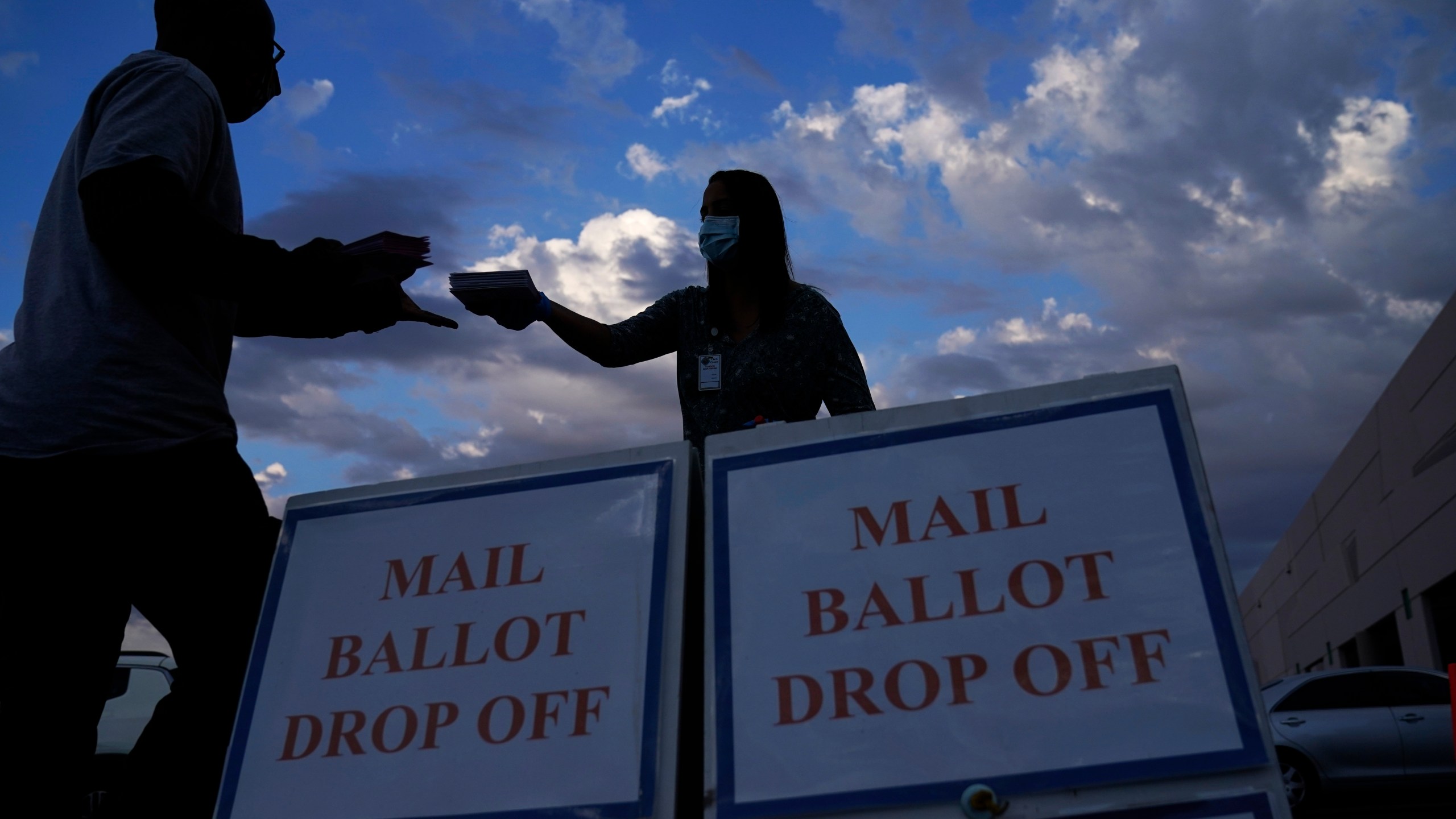 FILE - A county worker collects a mail-in ballots in a drive-thru mail-in ballot drop off area at the Clark County Election Department, Monday, Nov. 2, 2020, in Las Vegas. (AP Photo/John Locher, File)