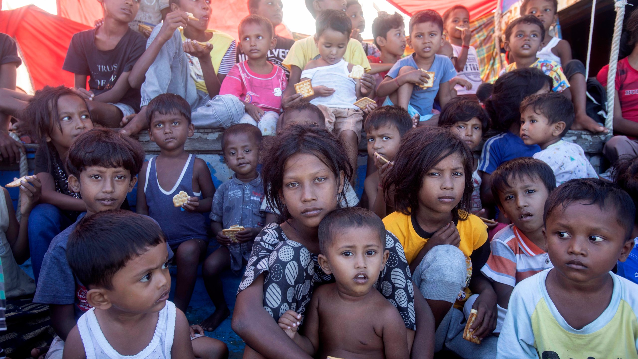 Rohingya refugee children sit on the deck of their boat anchored in the waters near the coast of Labuhan Haji, Aceh province, Indonesia, Tuesday, Oct. 22, 2024. (AP Photo/Binsar Bakkara)