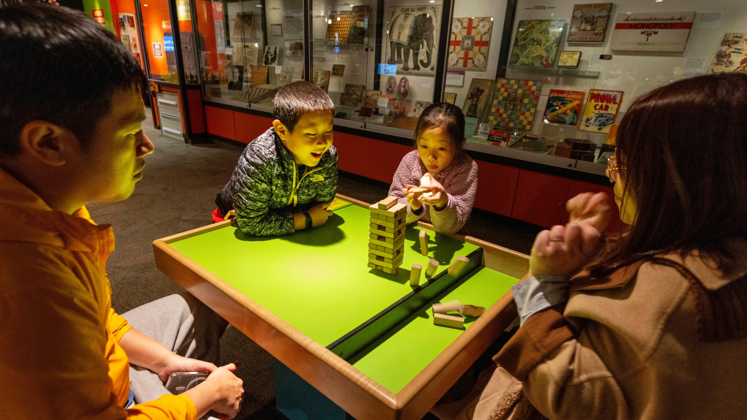 Jesse and Lydia Xu of Toronto play a game of Jenga with their kids Casper, 9, and Lydia, 8, at The Strong National Museum of Play, Tuesday, Oct. 15, 2024, in Rochester, N.Y. (AP Photo/Lauren Petracca)