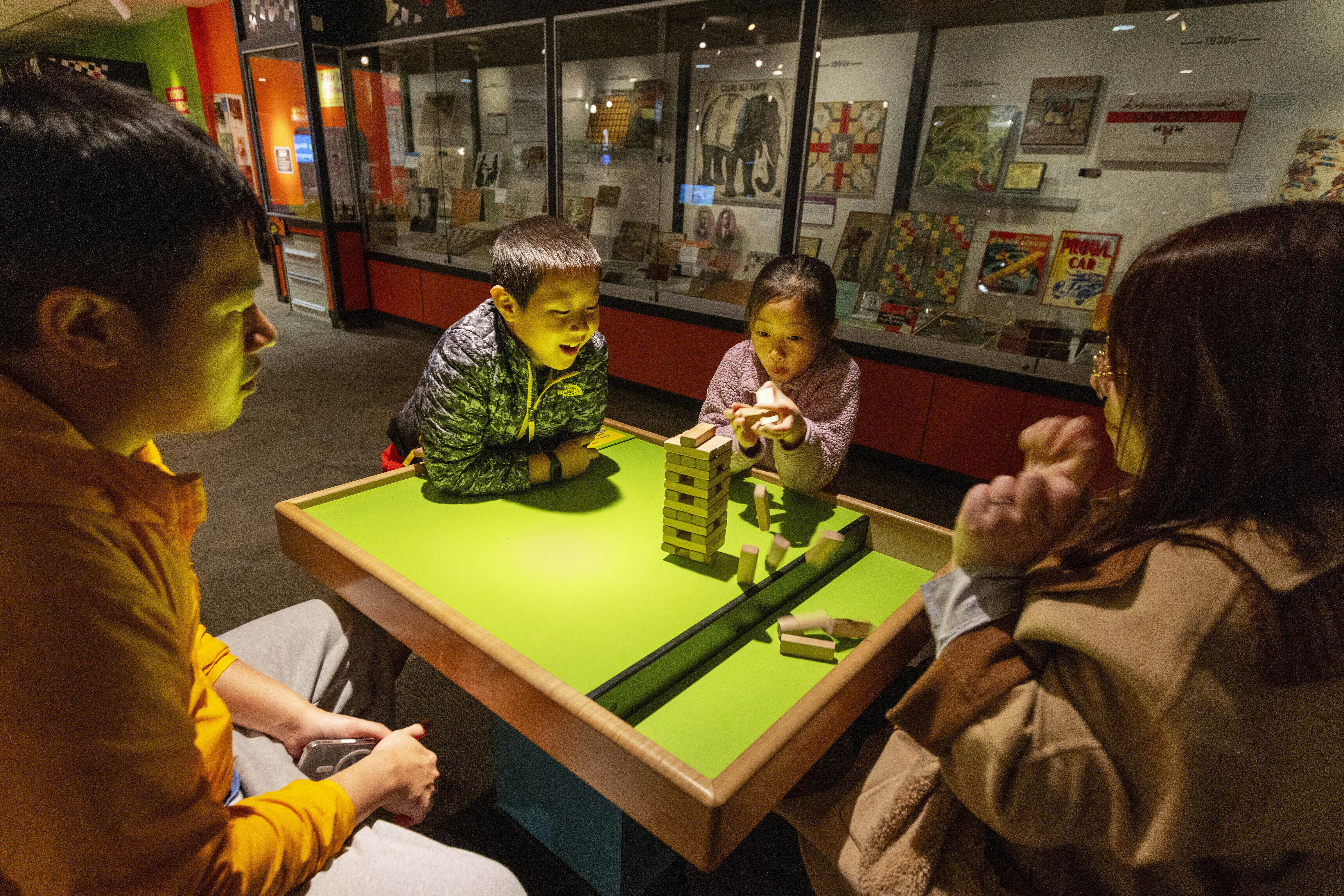 Jesse and Lydia Xu of Toronto play a game of Jenga with their kids Casper, 9, and Lydia, 8, at The Strong National Museum of Play, Tuesday, Oct. 15, 2024, in Rochester, N.Y. (AP Photo/Lauren Petracca)