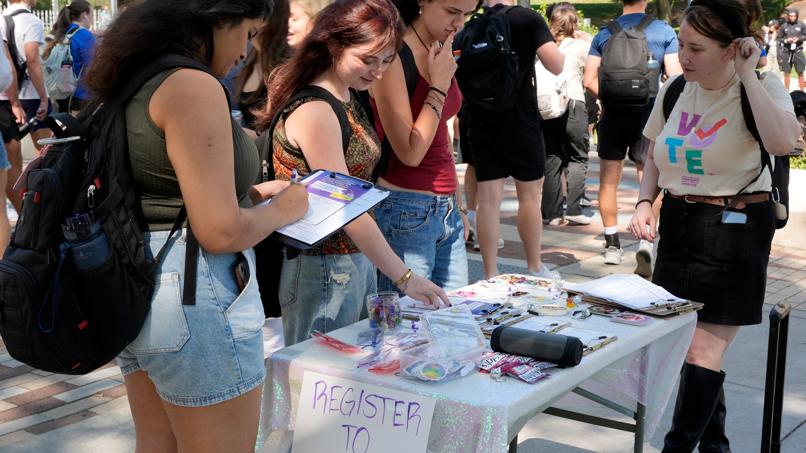 Cortney Bouse, right, explains registering to vote with University of Pittsburgh students on campus in Pittsburgh, Thursday, Sept. 12, 2024. (AP Photo/Gene J. Puskar)