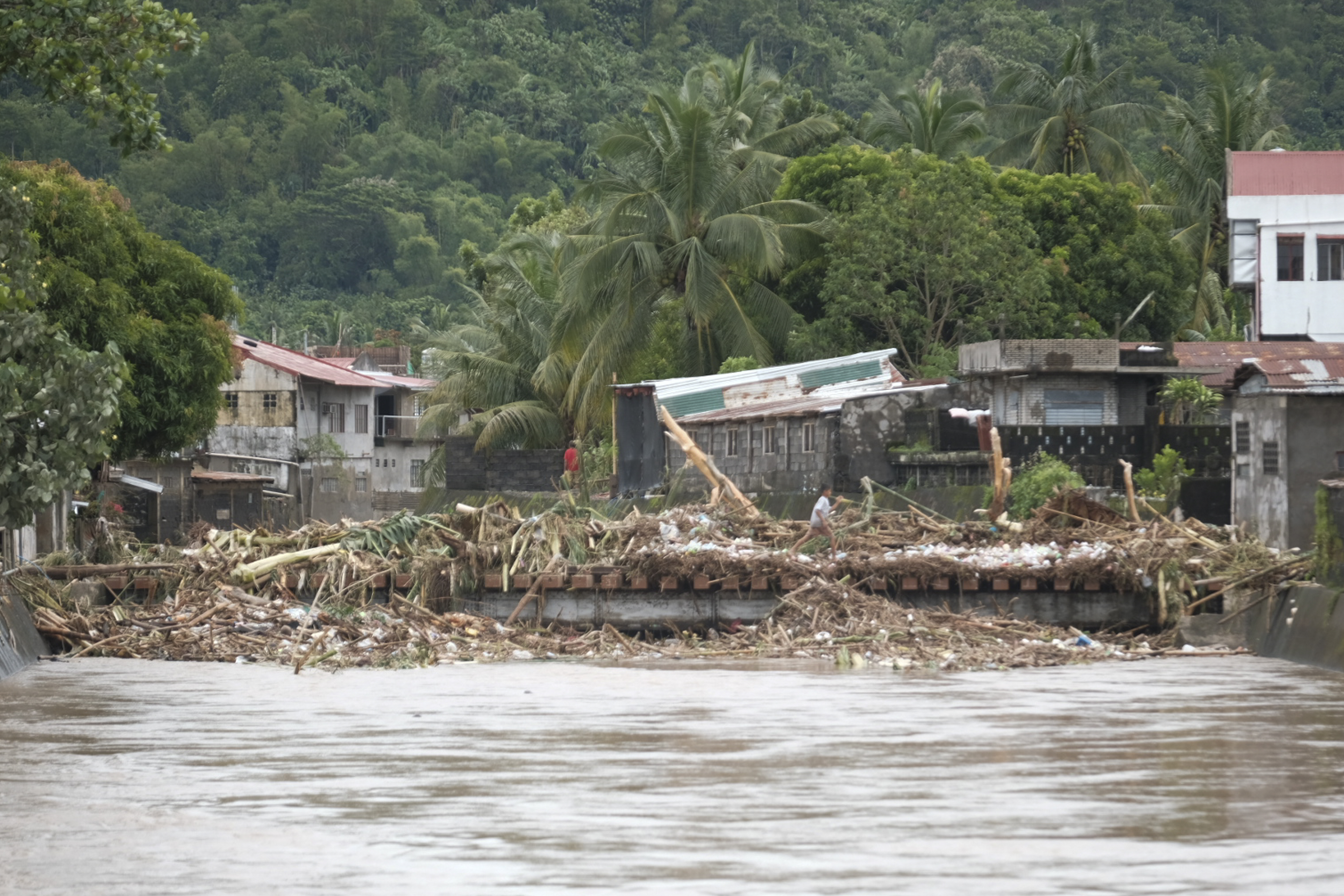 Debris from damages are gathered along a bridge after floods caused by Tropical Trami, locally named Kristine, hit Polangui, Albay province, Philippines on Oct. 23, 2024. (AP Photo/John Michael Magdasoc)