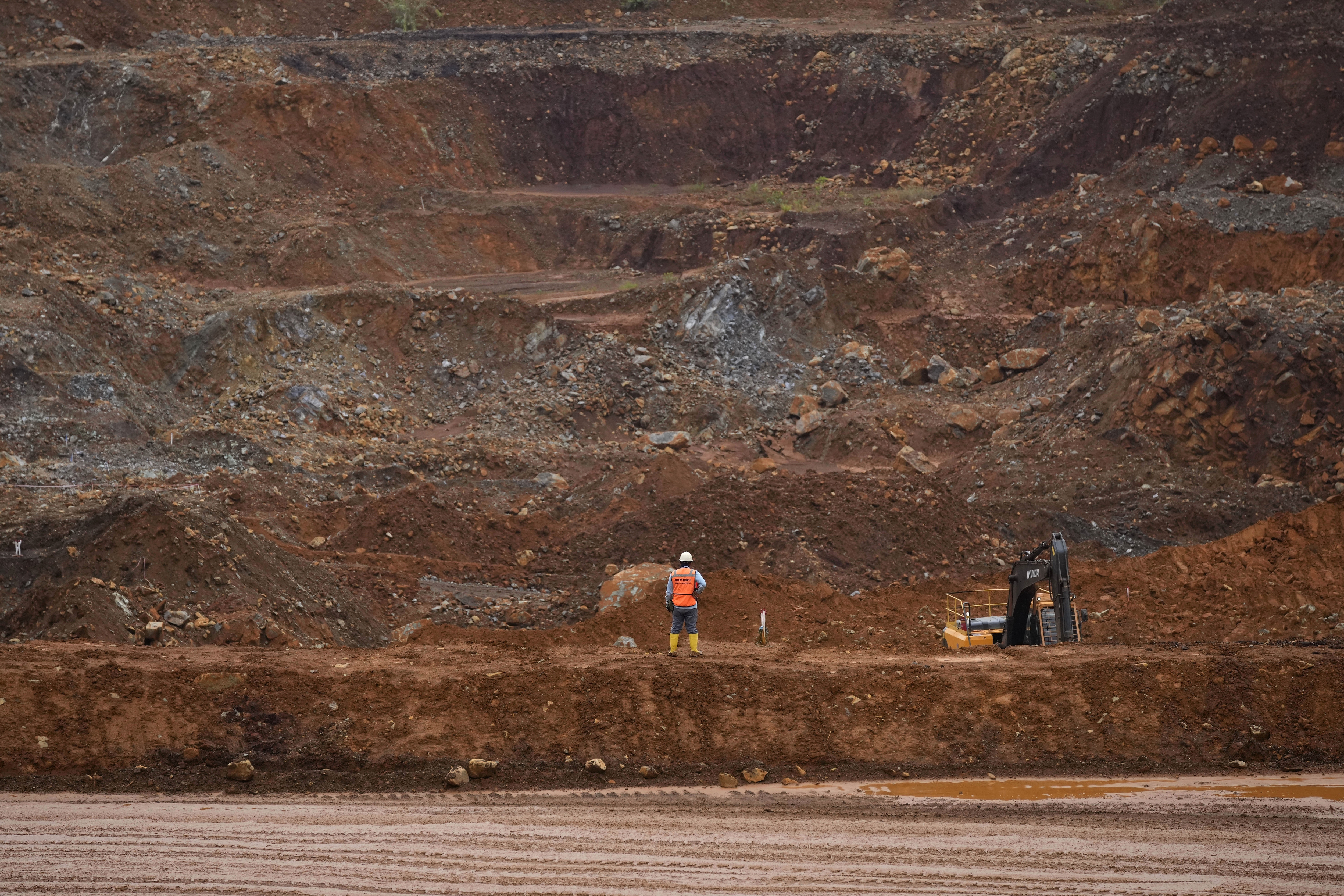 FILE - A worker stands near a mining pit at PT Vale Indonesia's nickel mine in Sorowako, South Sulawesi, Indonesia, on Sept. 12, 2023. (AP Photo/Dita Alangkara, File)