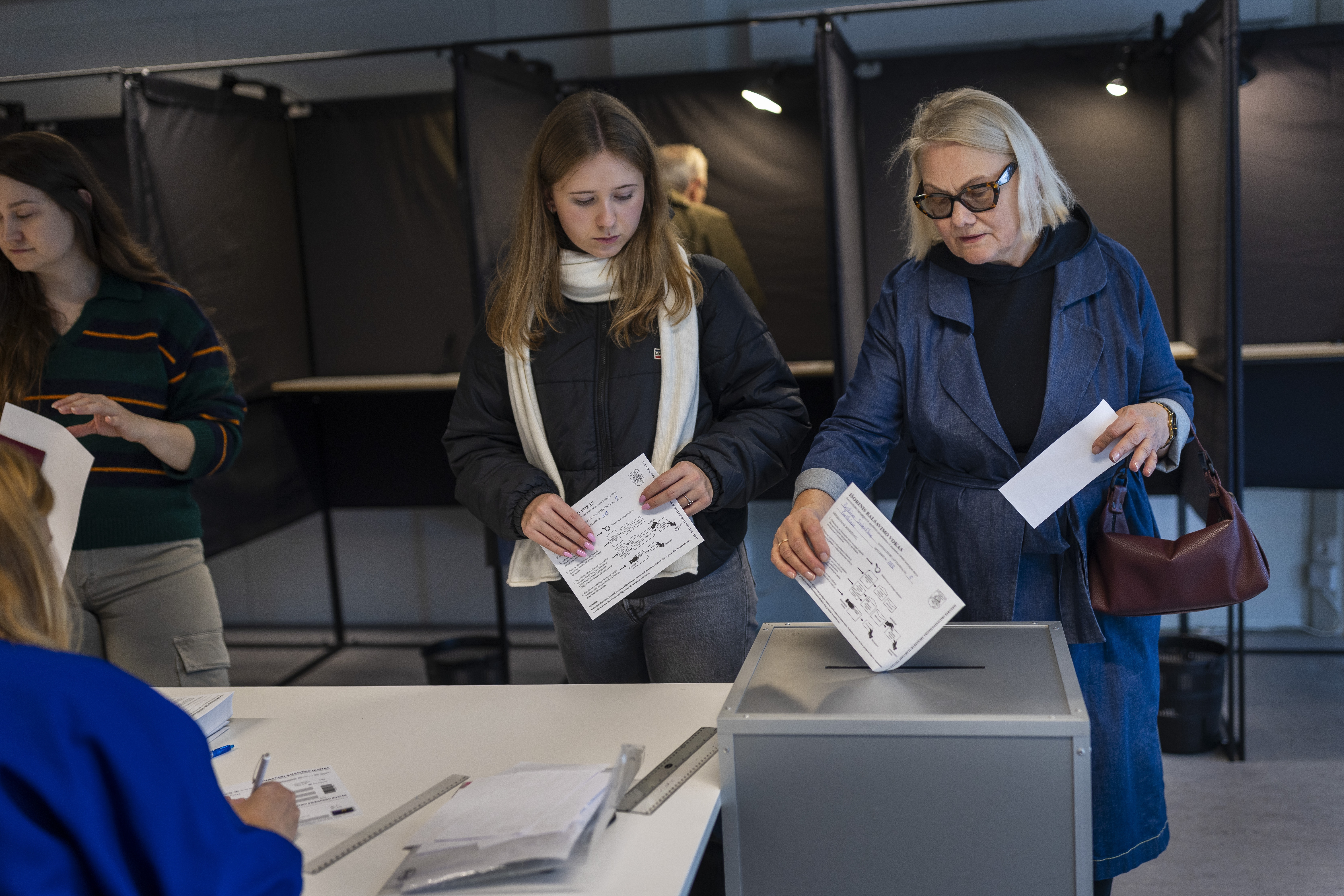 Local residents vote at a polling station during the advance voting in the second round of a parliamentary election in Vilnius, Lithuania, Tuesday, Oct. 22, 2024. (AP Photo/Mindaugas Kulbis)