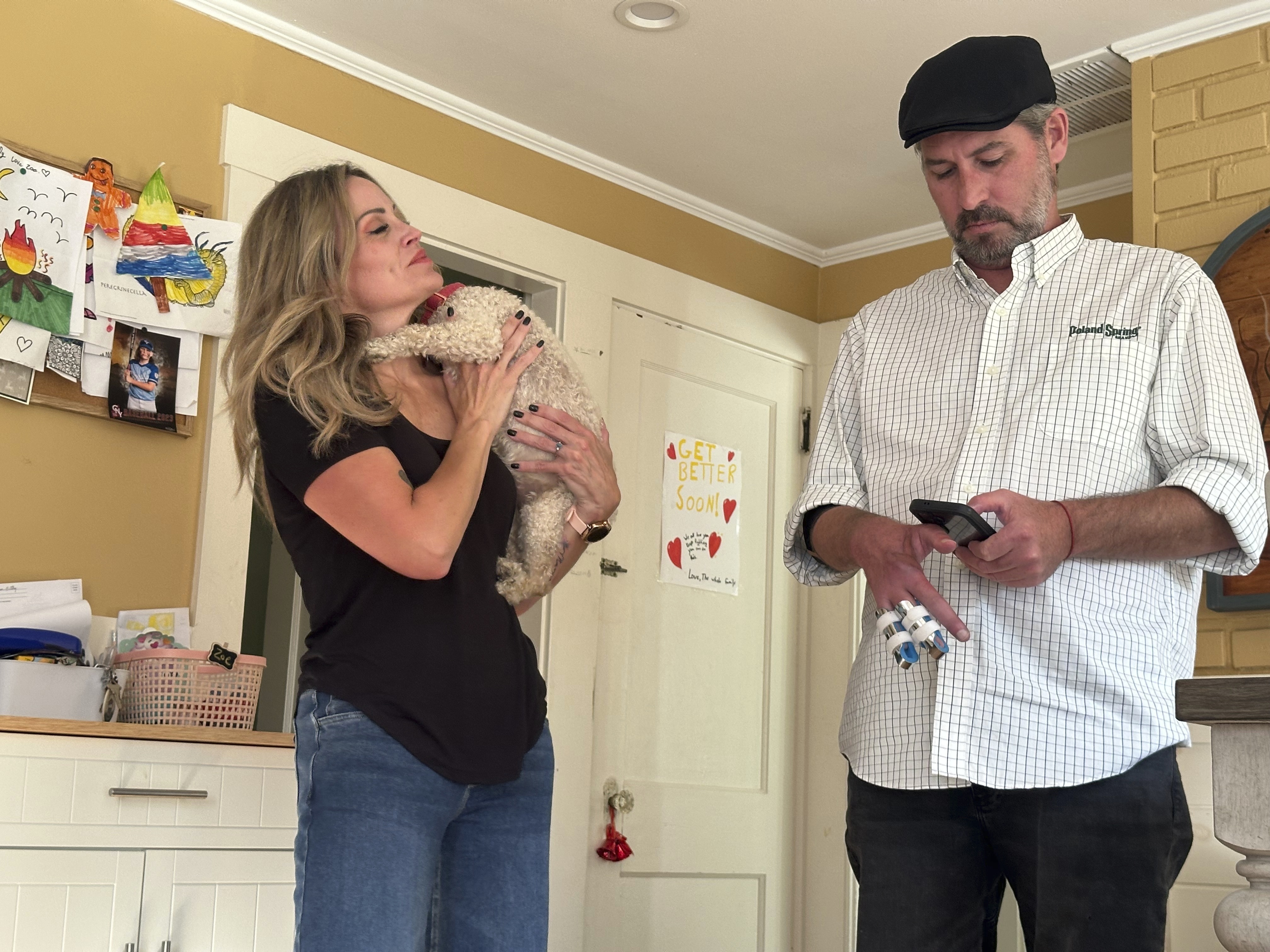 Lewiston mass shooting survivor Ben Dyer types on his phone while fiancée Keela Smith watches as they talk about the 2023 massacre and their plans for the future on Wednesday, Oct. 3, 2024 in Auburn, Maine. (AP Photo/Nick Perry)