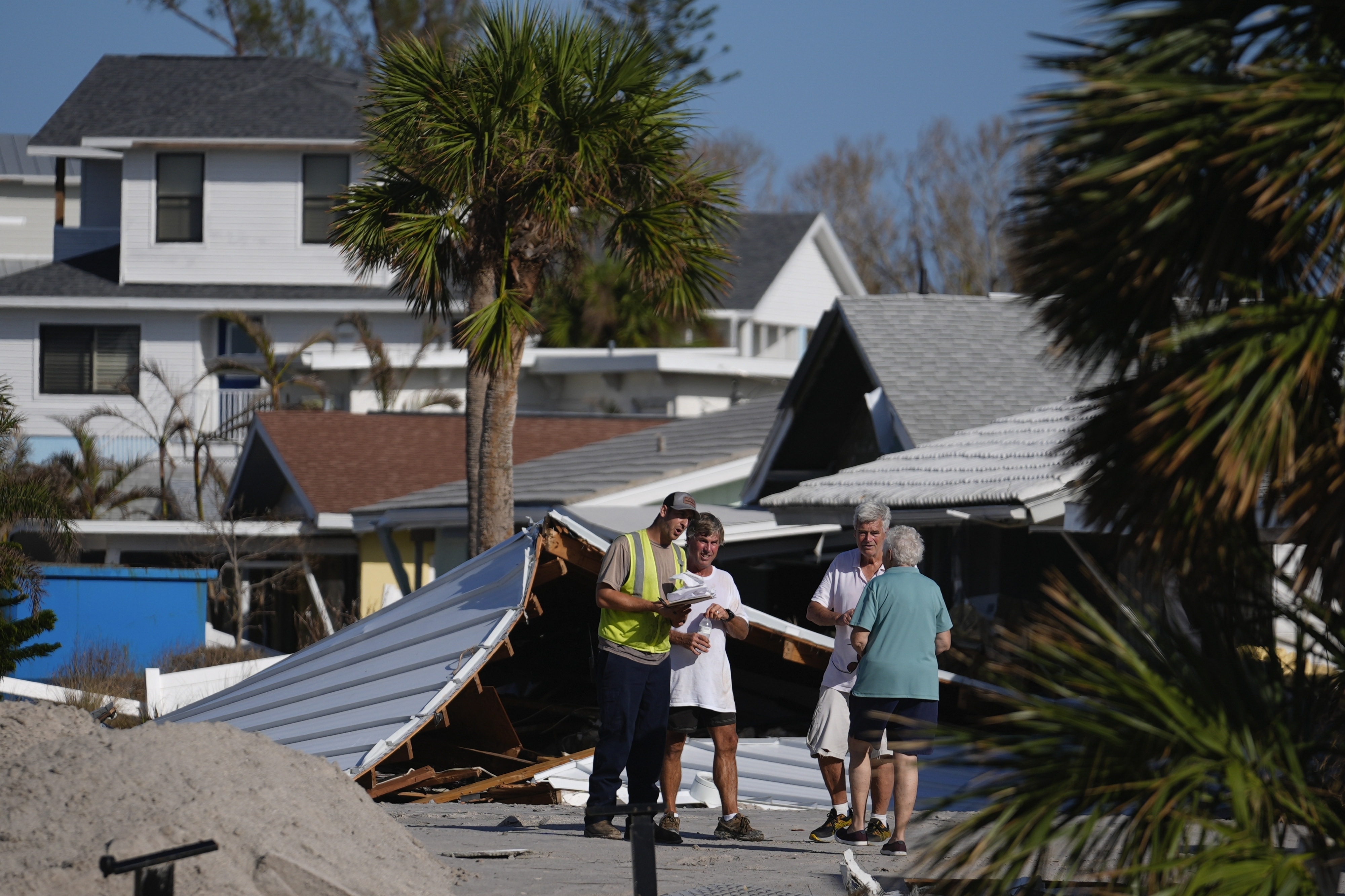 FILE - Property owners speak with an official as they process the damage to their homes and community following Hurricane Milton, on Manasota Key, in Englewood, Fla., Sunday, Oct. 13, 2024. (AP Photo/Rebecca Blackwell)