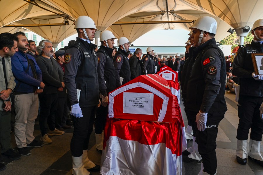 Turkish soldiers stand next to the coffins of Zahide Guglu Ekici, Hasan Huseyin Canbaz and Cengiz Coskun during their funeral at Karsiyaka mosque in Ankara, Thursday, Oct. 24, 2024, a day after they were killed during an attack by PKK members at the Turkish aerospace and defense company TUSAS on Wednesday. (AP Photo/Ali Unal)