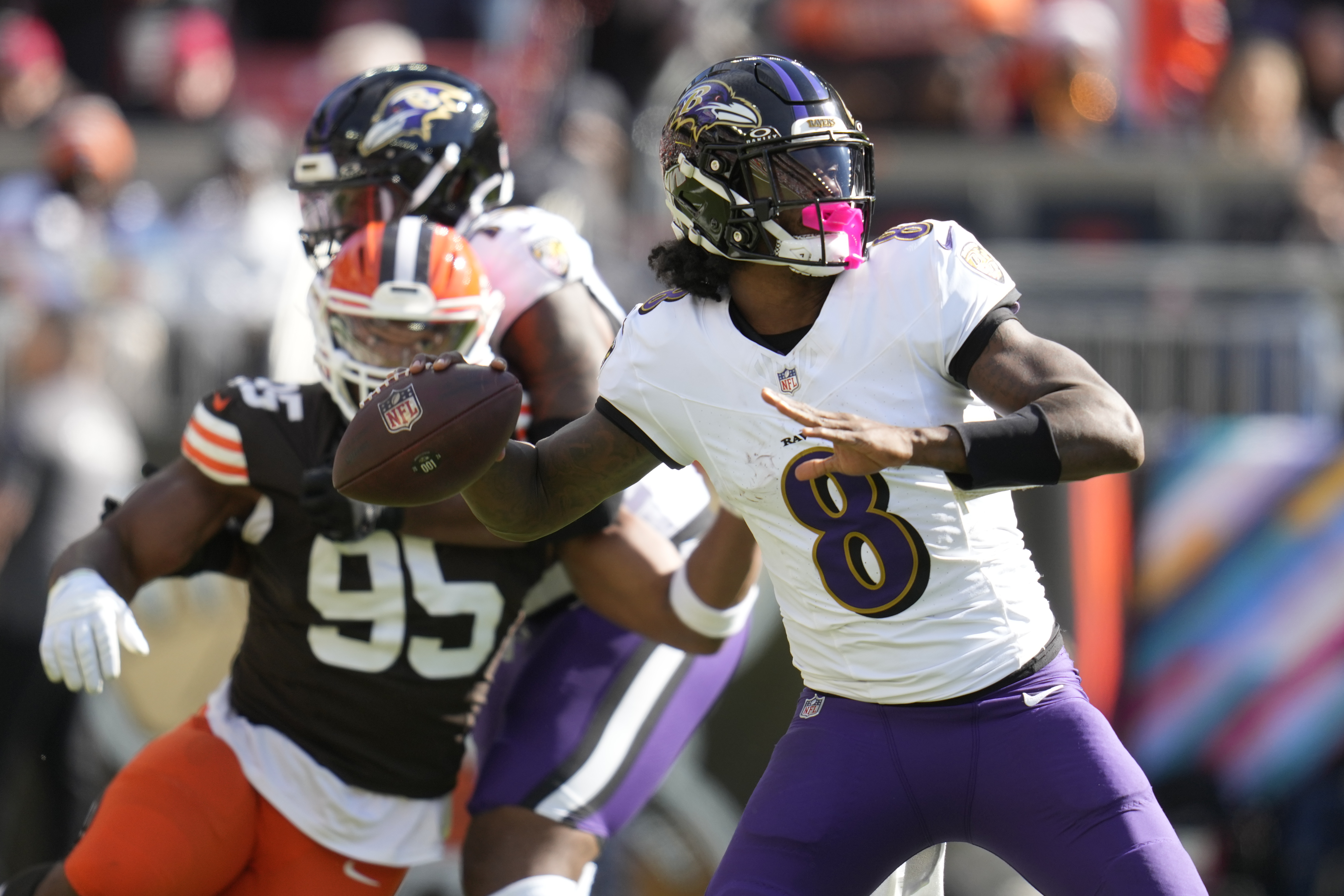 Baltimore Ravens quarterback Lamar Jackson (8) throws in from top Cleveland Browns defensive end Myles Garrett (95) during the first half of an NFL football game in Cleveland, Sunday, Oct. 27, 2024. (AP Photo/Sue Ogrocki)