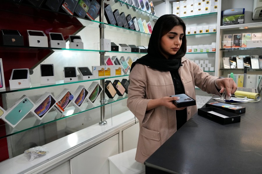 FILE - A cellphone vendor works at her shop in downtown Tehran, Iran, Wednesday, Feb. 21, 2024. (AP Photo/Vahid Salemi, File)