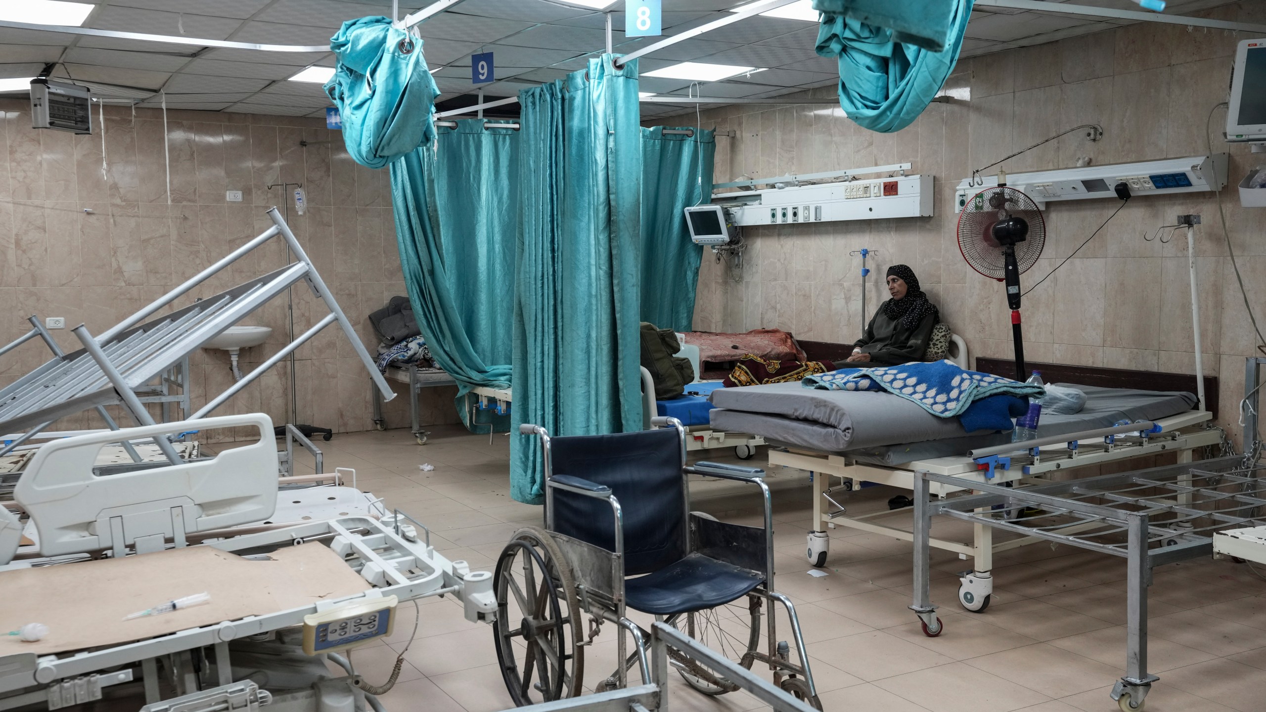 FILE - A woman sits on a bed in a room of the Al-Aqsa Martyrs hospital in Deir al Balah, Gaza Strip, Aug. 25, 2024. (AP Photo/Abdel Kareem Hana, File)