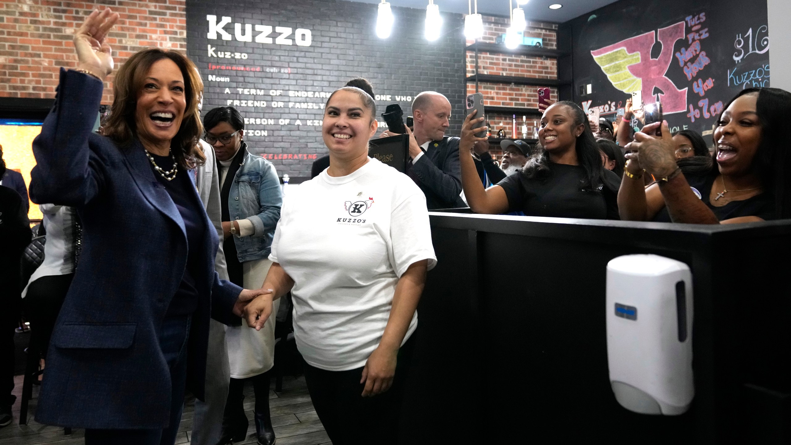 Democratic presidential nominee Vice President Kamala Harris, from left, greets a member of the restaurant staff during a campaign stop at Kuzzo's Chicken and Waffles in Detroit, Sunday, Nov. 3, 2024. (AP Photo/Jacquelyn Martin)