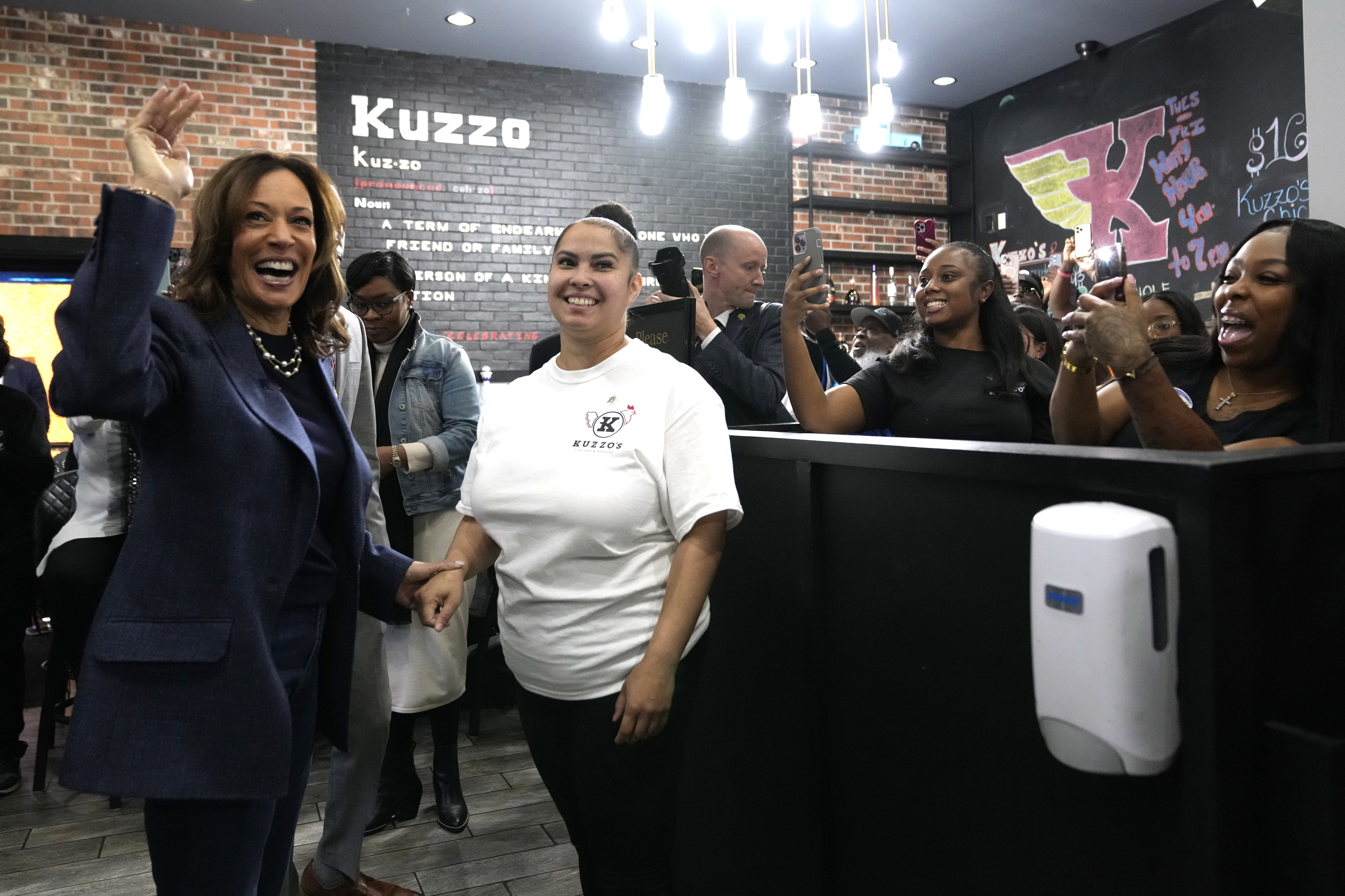 Democratic presidential nominee Vice President Kamala Harris, from left, greets a member of the restaurant staff during a campaign stop at Kuzzo's Chicken and Waffles in Detroit, Sunday, Nov. 3, 2024. (AP Photo/Jacquelyn Martin)