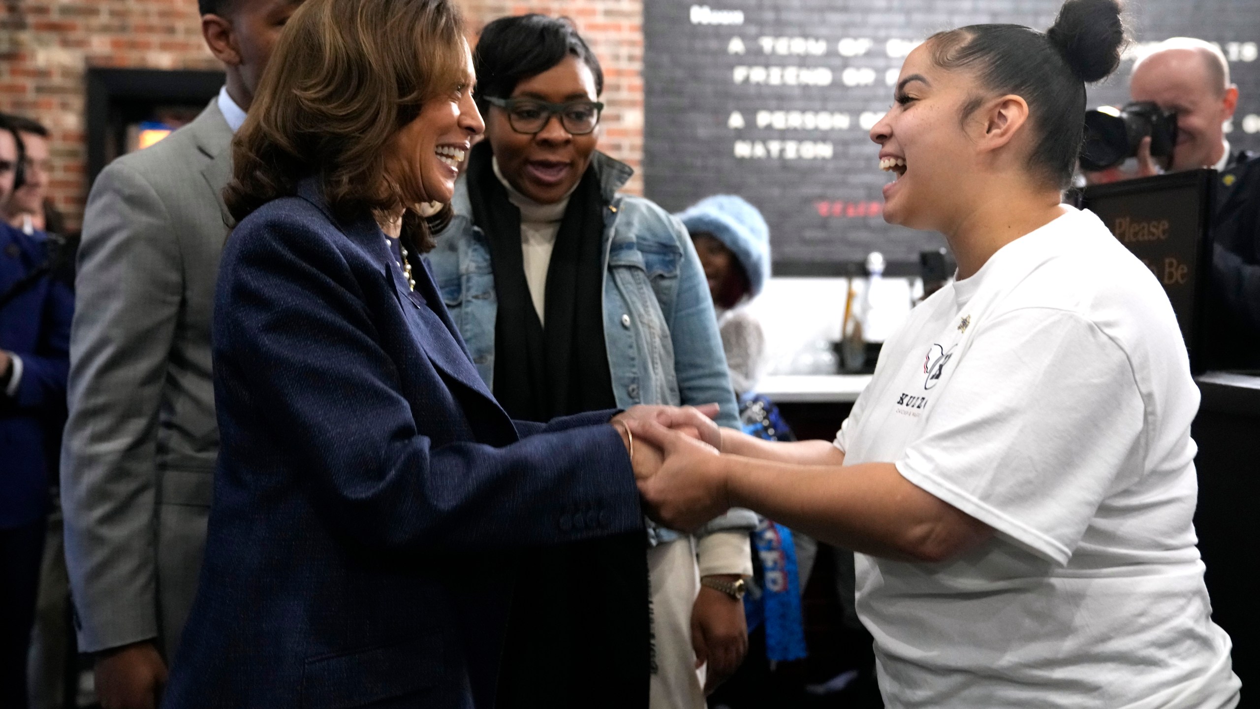 Democratic presidential nominee Vice President Kamala Harris, left, greets a member of the restaurant staff during a campaign stop at Kuzzo's Chicken and Waffles in Detroit, Sunday, Nov. 3, 2024. (AP Photo/Jacquelyn Martin)