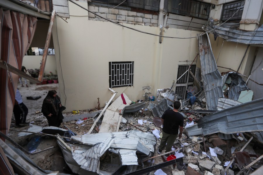 People inspect a destroyed building hit in an Israeli airstrike, in the southern port city of Sidon, Lebanon, Sunday, Nov. 3, 2024. (AP Photo/Mohammed Zaatari)