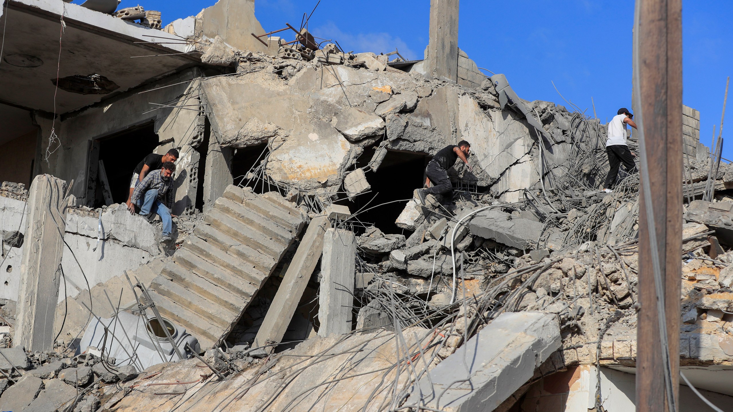 People search for victims at a destroyed building hit in an Israeli airstrike, in Ghaziyeh town, south Lebanon, Sunday, Nov. 3, 2024. (AP Photo/Mohammed Zaatari)