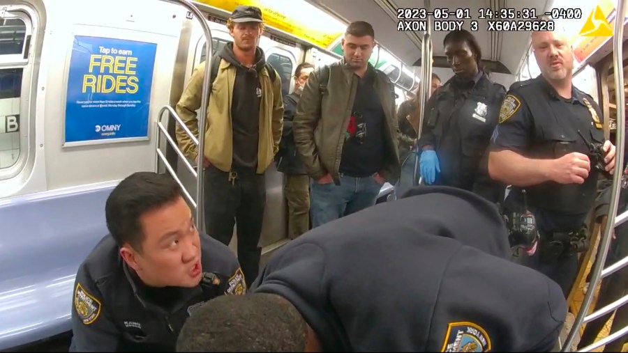 This image from body camera video provided by New York City Police Department, Daniel Penny, standing at left, looks on in a New York City subway car as officers attempt to revive Jordan Neely onMay 5, 2023. (New York City Police Department via AP)