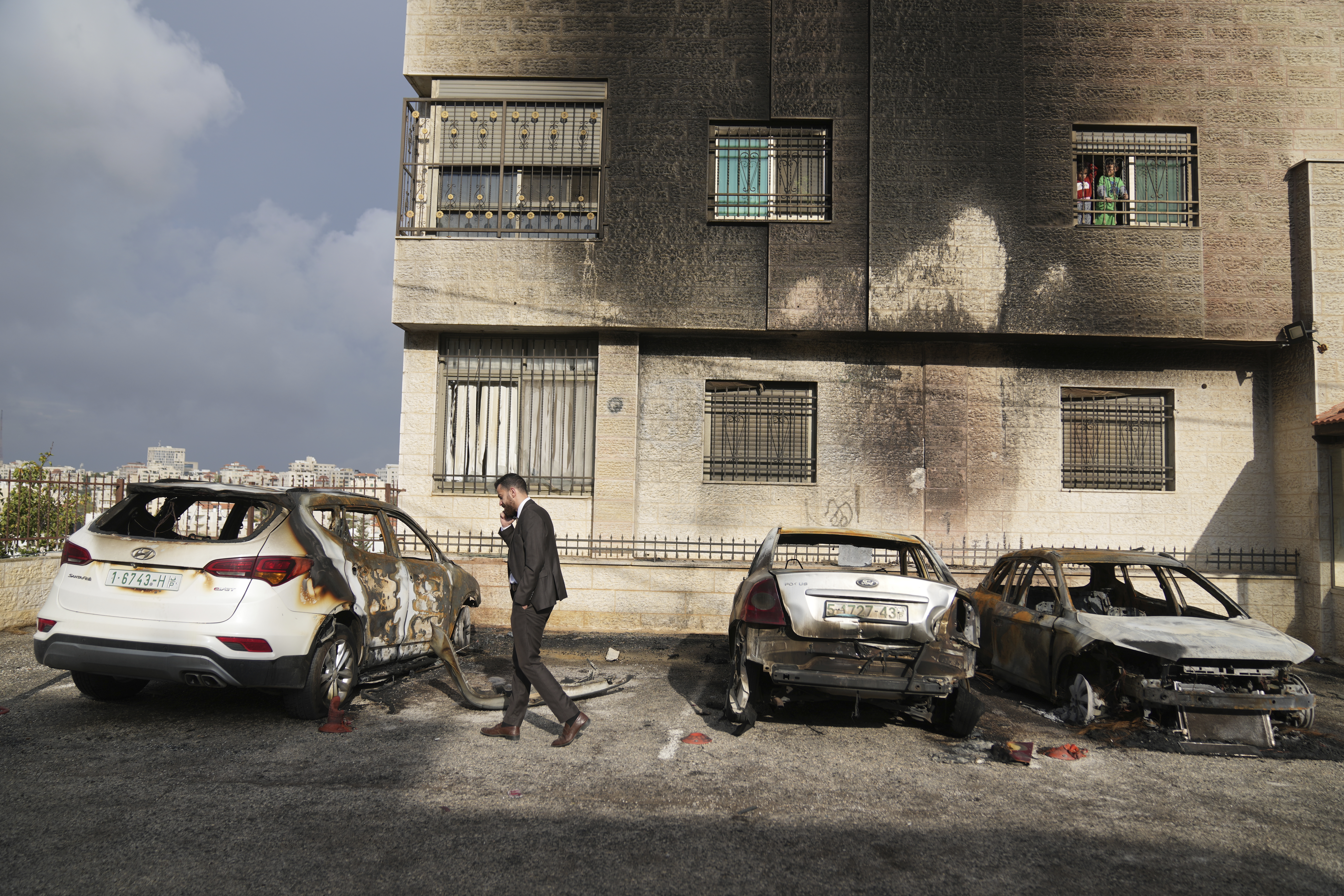 Palestinians inspect vehicles that were burnt during an early morning attack by Israeli settlers, that left at least 18 burnt vehicles, on the outskirts of the West Bank city of al-Bireh Monday, Nov. 4, 2024. (AP Photo/Nasser Nasser)