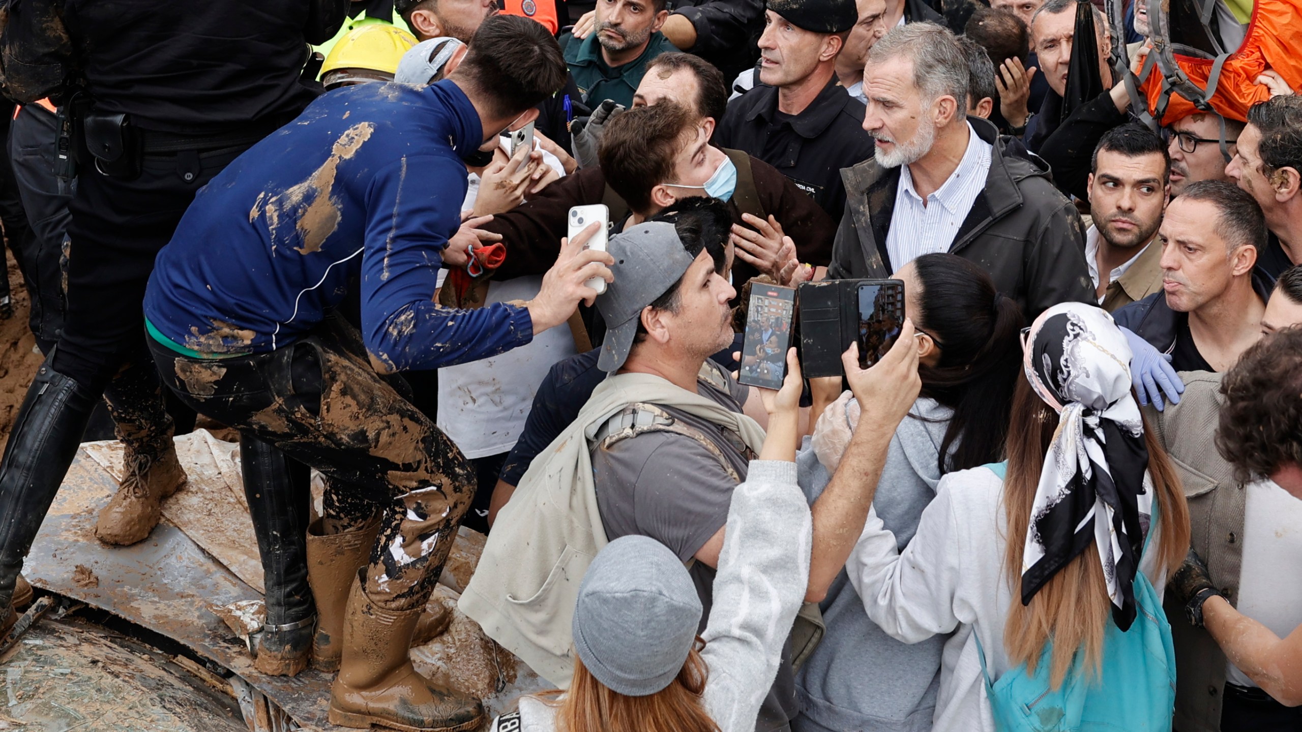 Spain's King Felipe VI, centre right, speaks with protesters in Paiporta, near Valencia, Spain, A crowd of angry survivors of Spain's floods have tossed mud and shouted insults at Spain's King Felipe VI and government officials when they made their first visit to one of the hardest hit towns. (Biel Alino/EFE via AP)