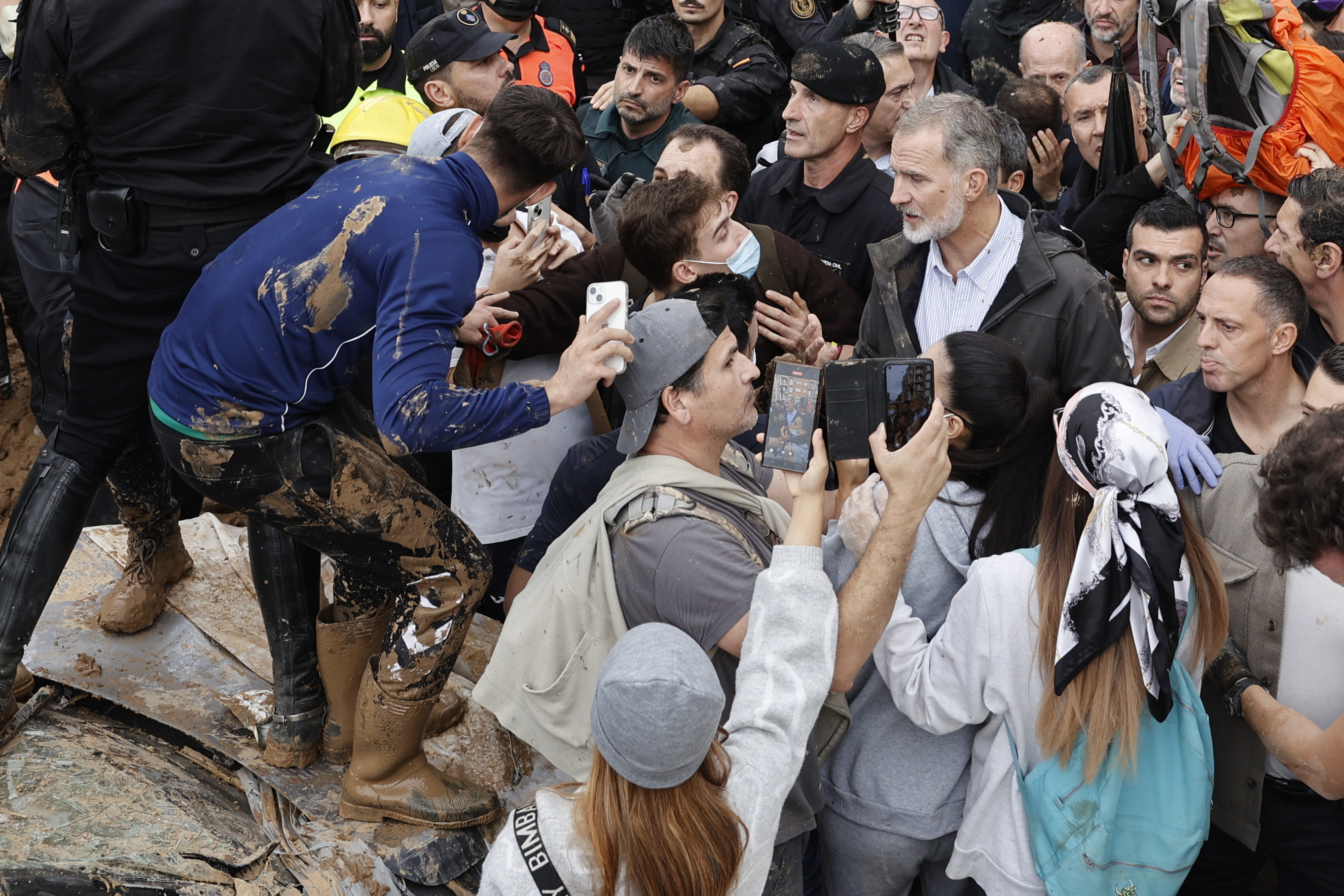 Spain's King Felipe VI, centre right, speaks with protesters in Paiporta, near Valencia, Spain, A crowd of angry survivors of Spain's floods have tossed mud and shouted insults at Spain's King Felipe VI and government officials when they made their first visit to one of the hardest hit towns. (Biel Alino/EFE via AP)