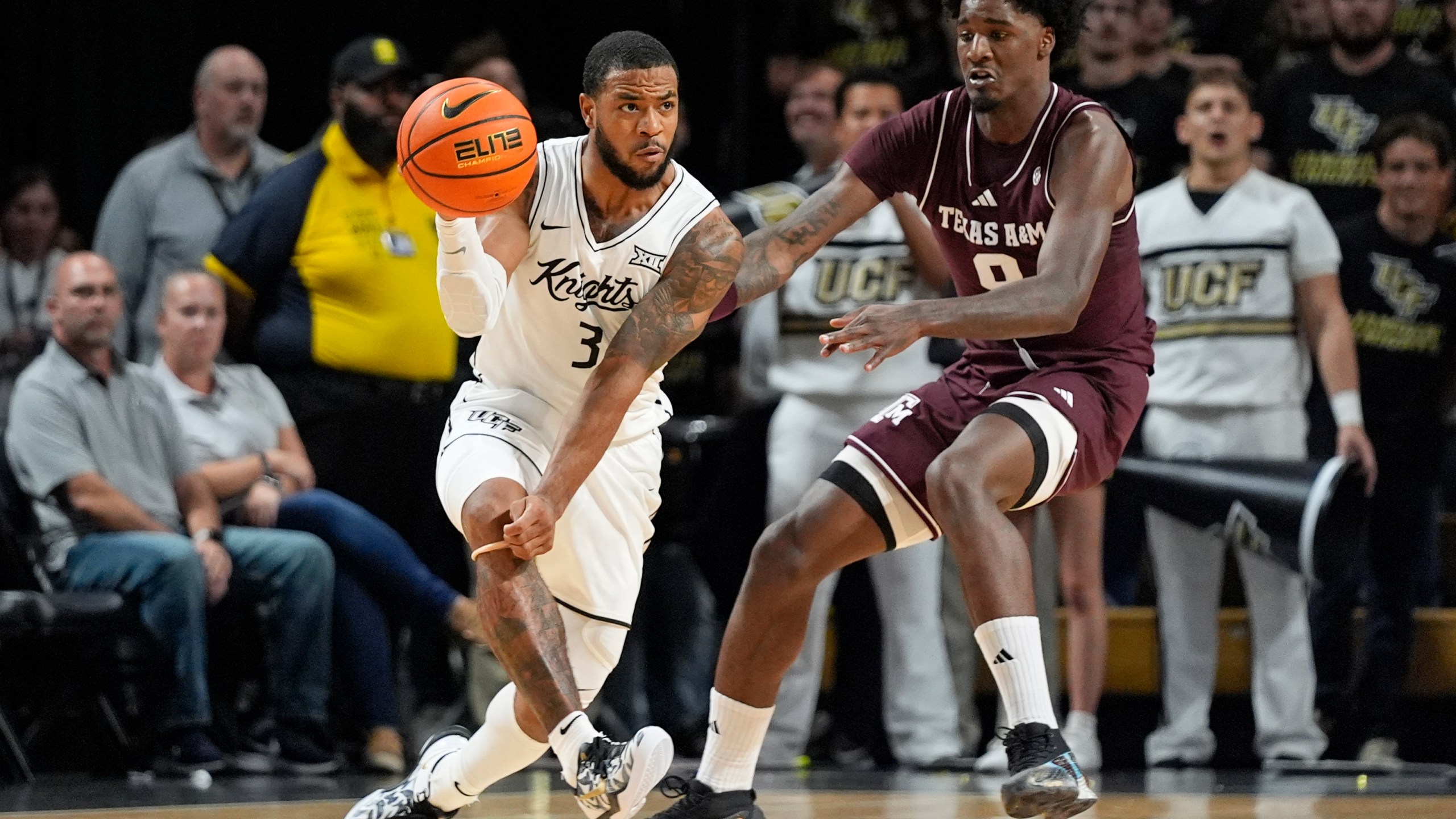 Central Florida guard Darius Johnson (3) passes the ball as he is defended by Texas A&M forward Solomon Washington, right, during the first half of an NCAA college basketball game, Monday, Nov. 4, 2024, in Orlando, Fla. (AP Photo/John Raoux)